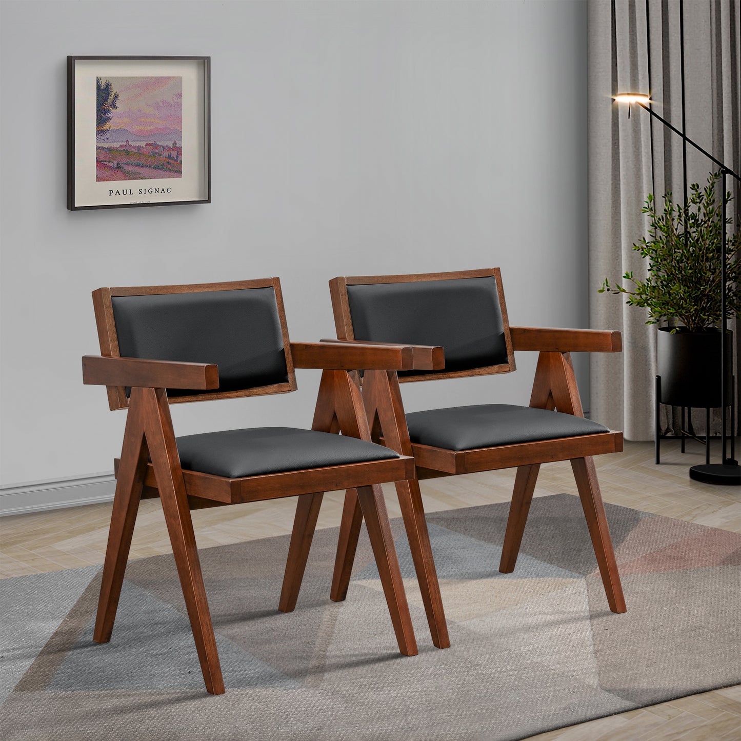 Two dark wood accent chairs with black faux leather seats and armrests on a patterned rug