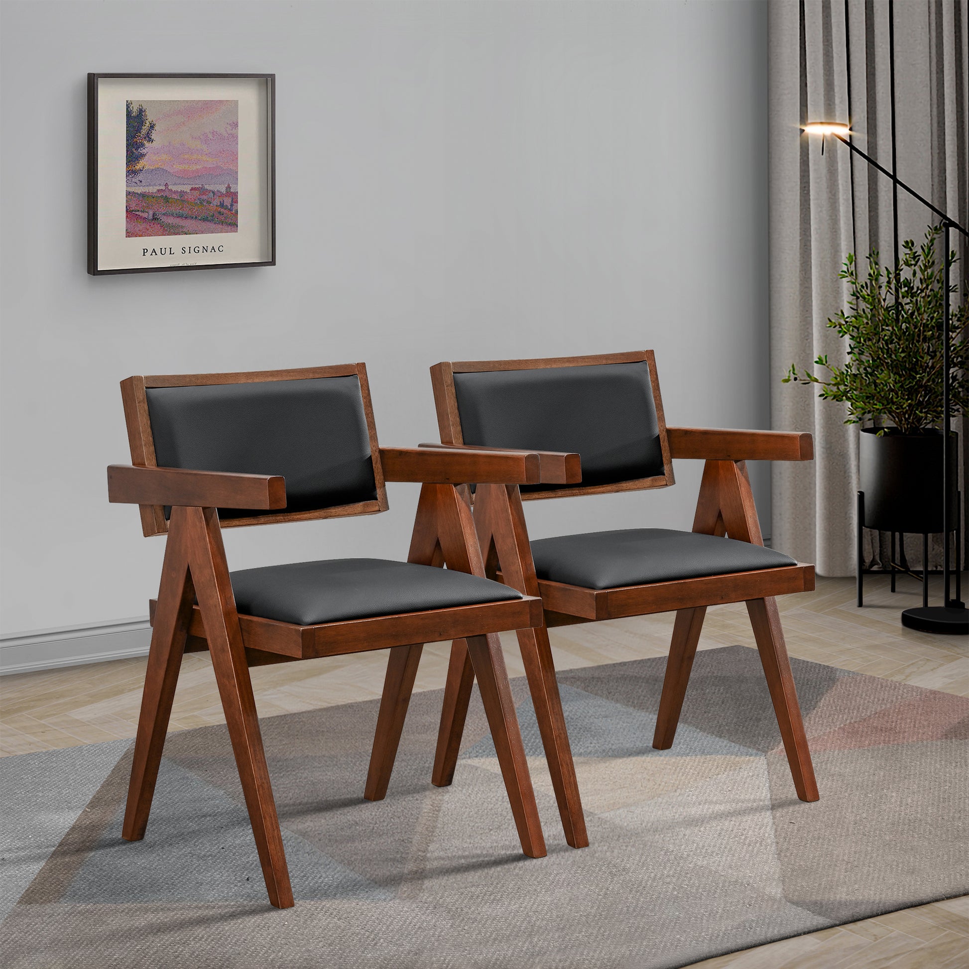 Two dark wood accent chairs with black faux leather seats and armrests on a patterned rug