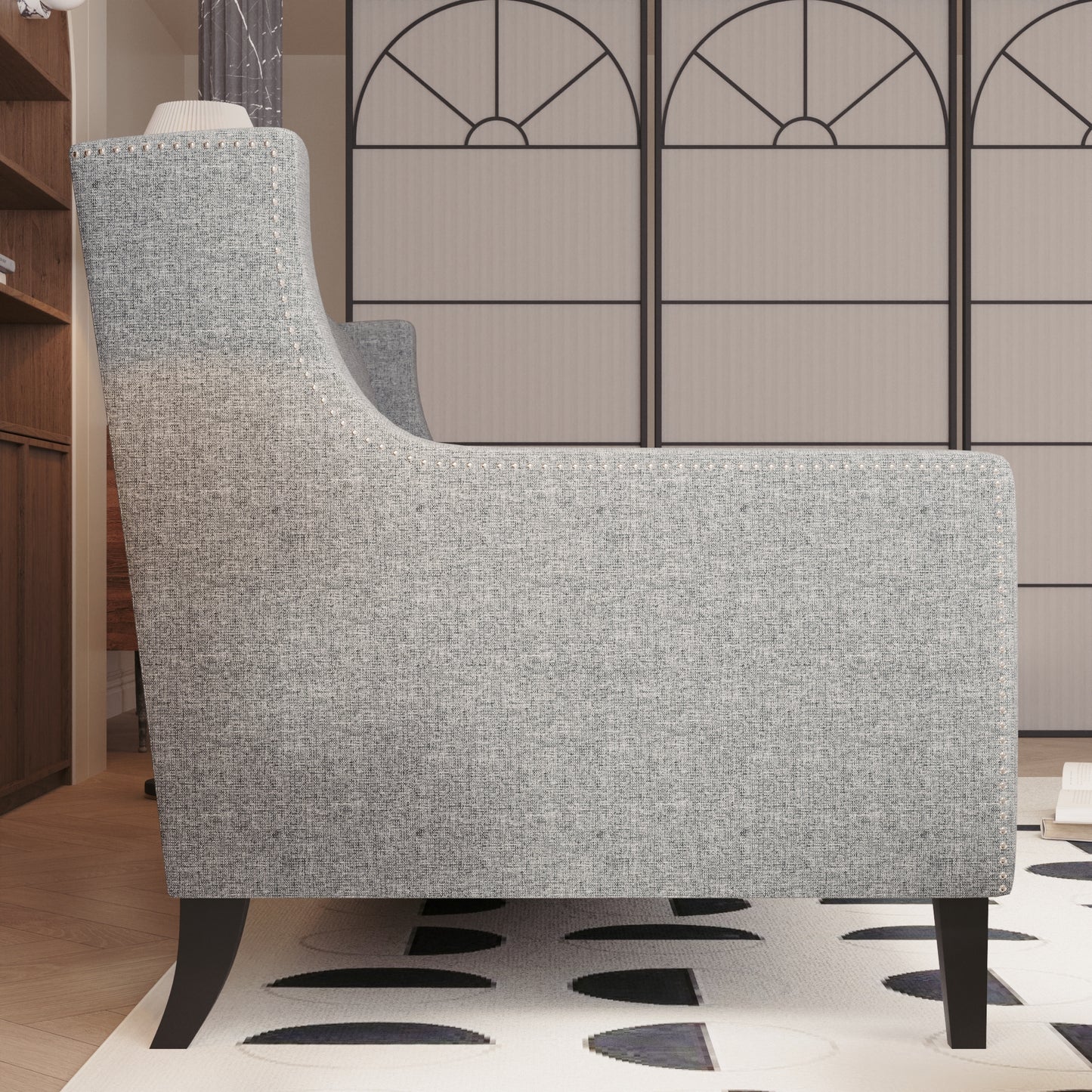 Gray fabric armchair with decorative nailhead trim and dark wood legs