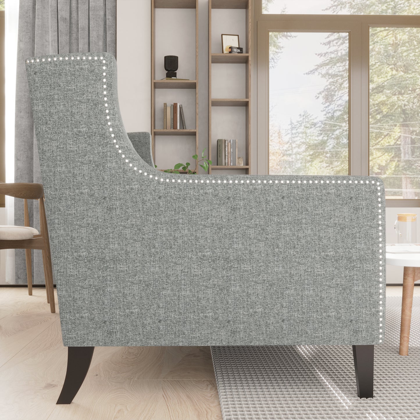 Grey upholstered accent chair with nailhead trim and dark tapered legs
