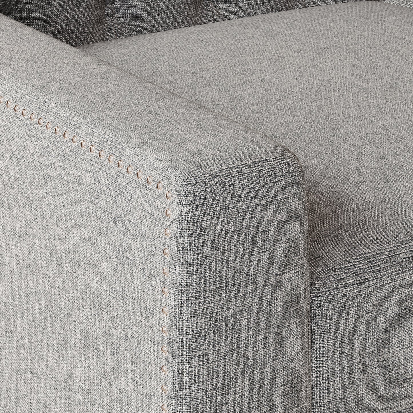 Closeup of grey textured fabric sofa arm with decorative nailhead trim detail