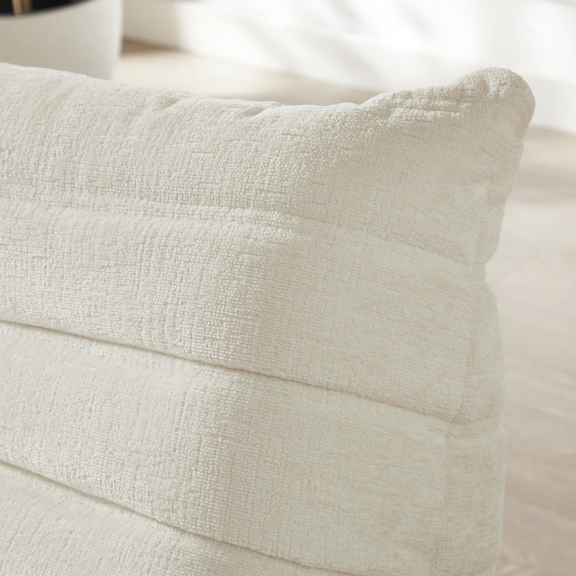 Cream textured throw pillow with subtle horizontal ribbing detail
