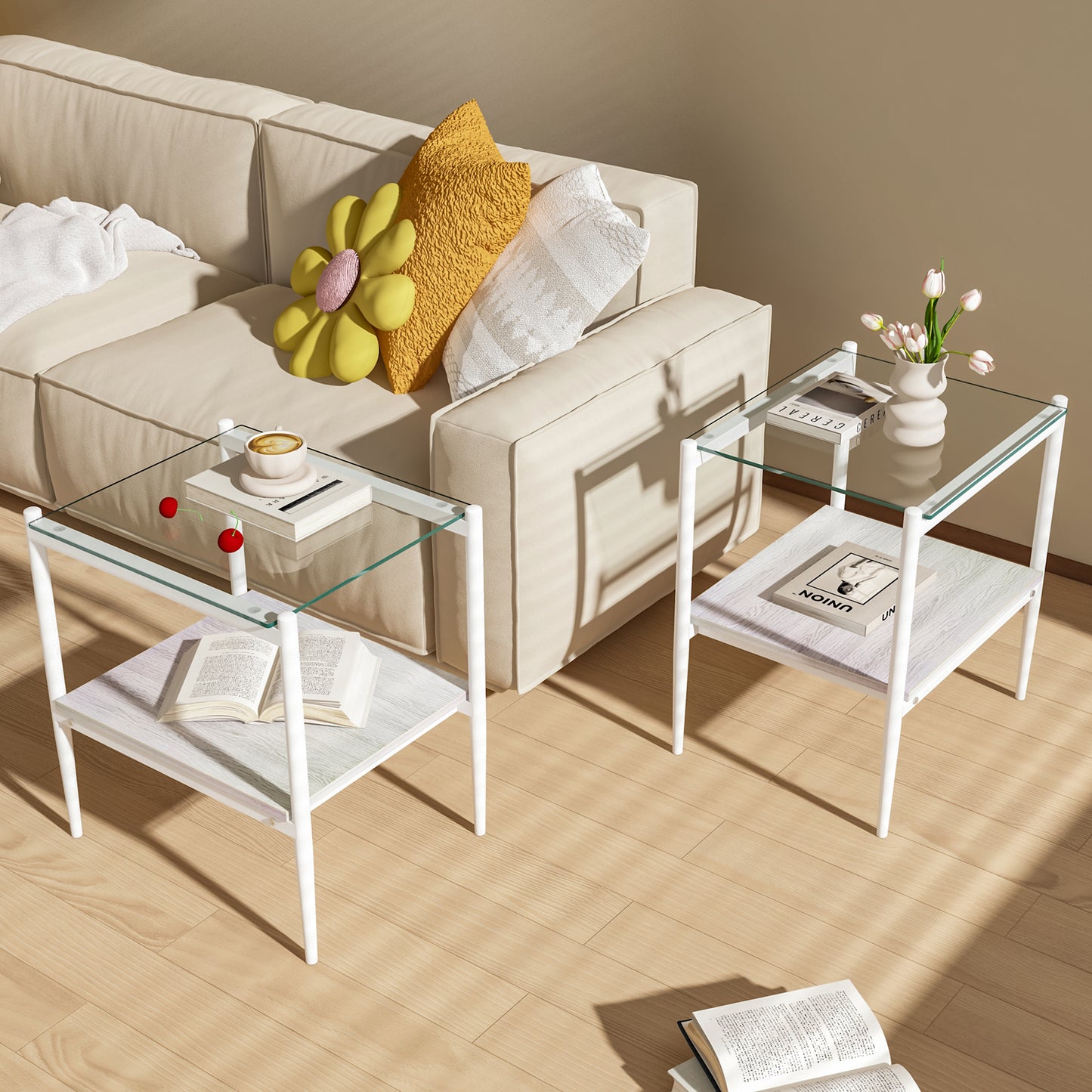 Two white metal and glass end tables with wooden shelves styled with books and decor