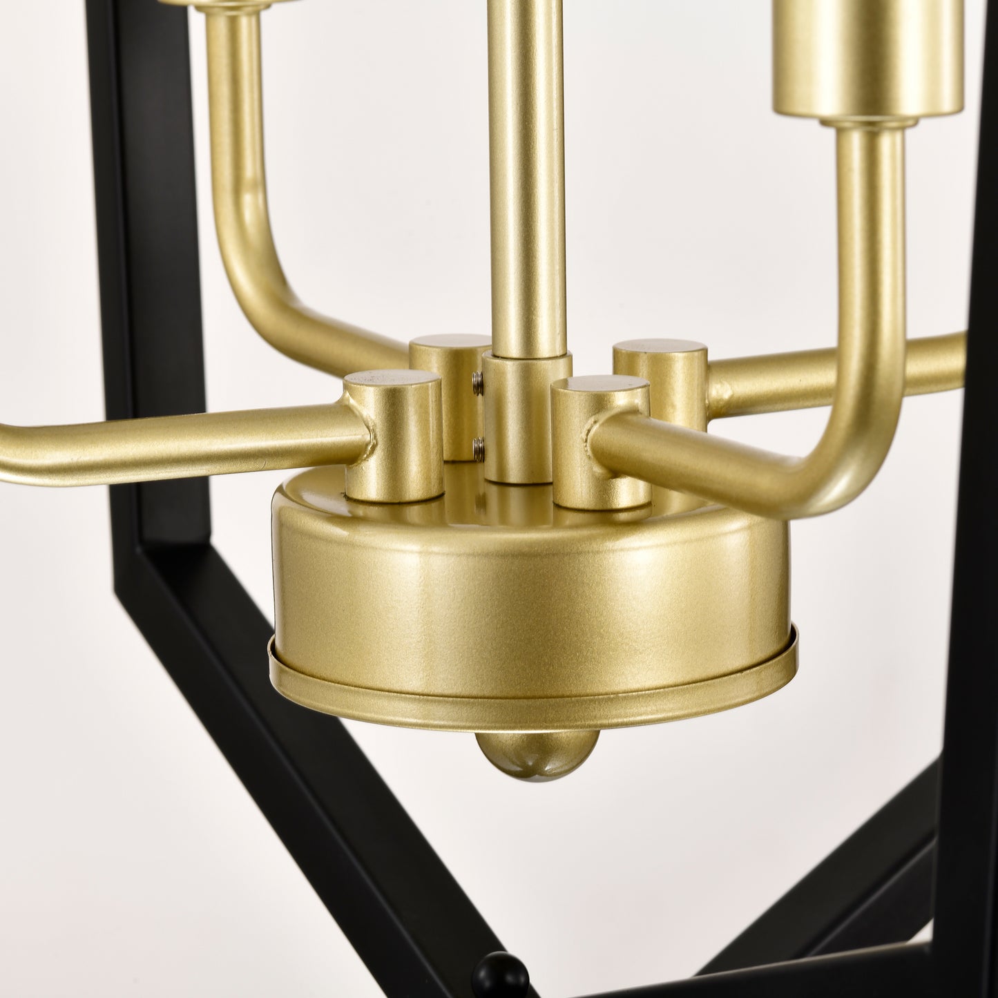 Closeup of a brushed brass chandelier stem and black metal frame detail
