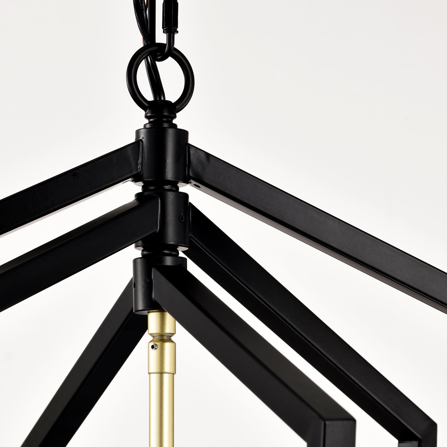 Closeup of a black metal geometric chandelier frame with gold accents
