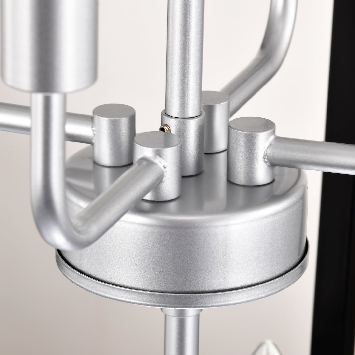 Closeup of a brushed nickel chandelier arm detail with mounting caps