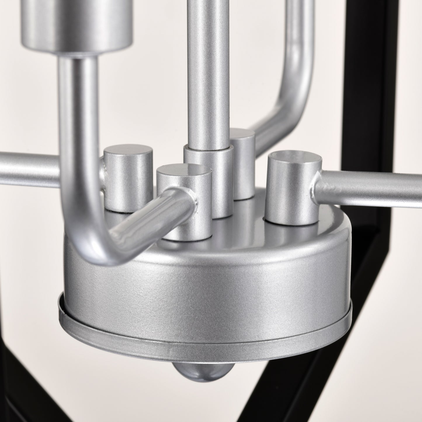 Silver metal chandelier detail with curved arms and cylindrical accents