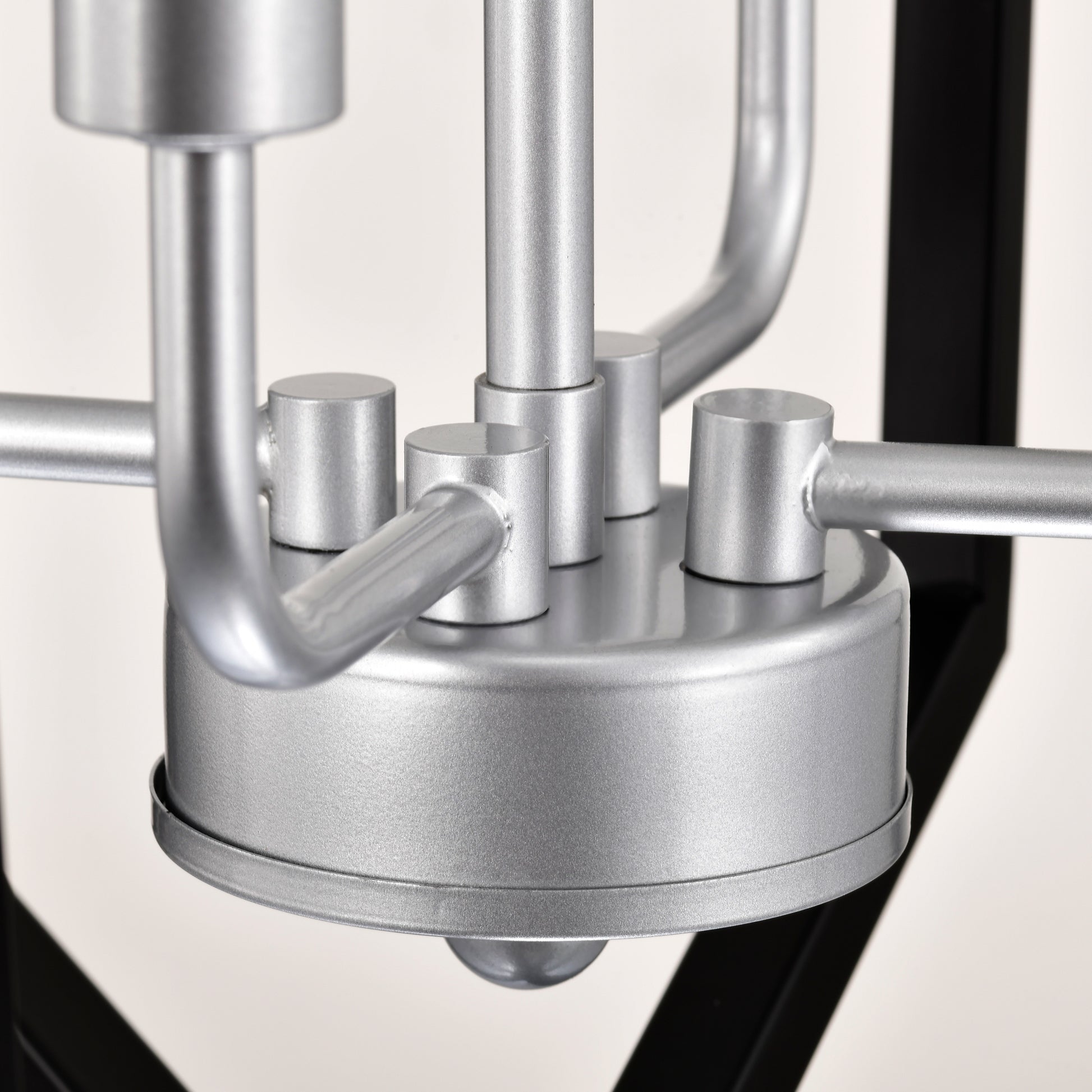 Silver metal chandelier detail with curved arms and cylindrical accents