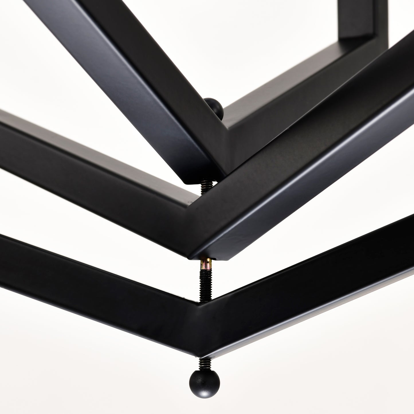Closeup of black metal geometric shelf bracket with threaded bolt