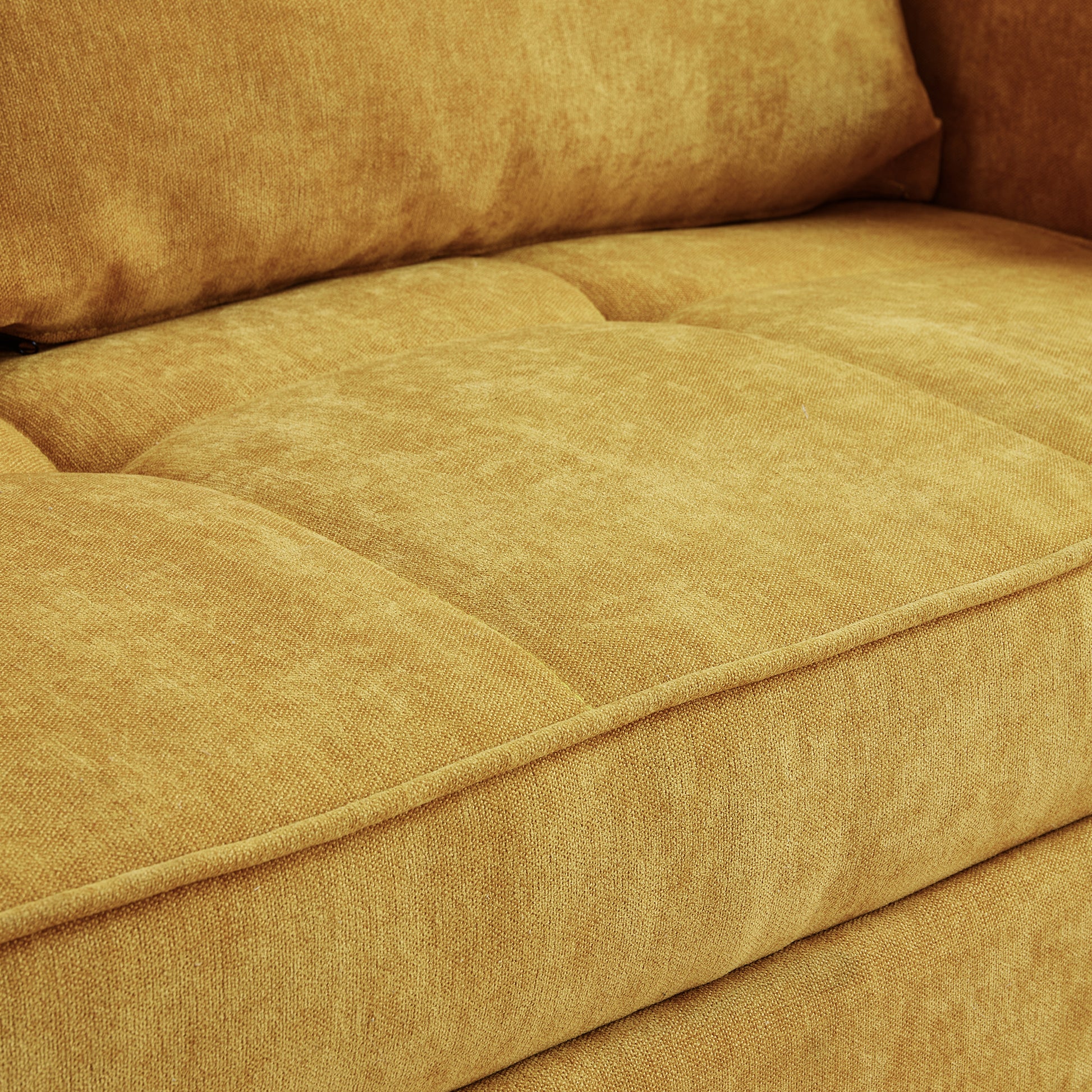 Closeup of a textured mustard yellow sofa cushion with tufted detail