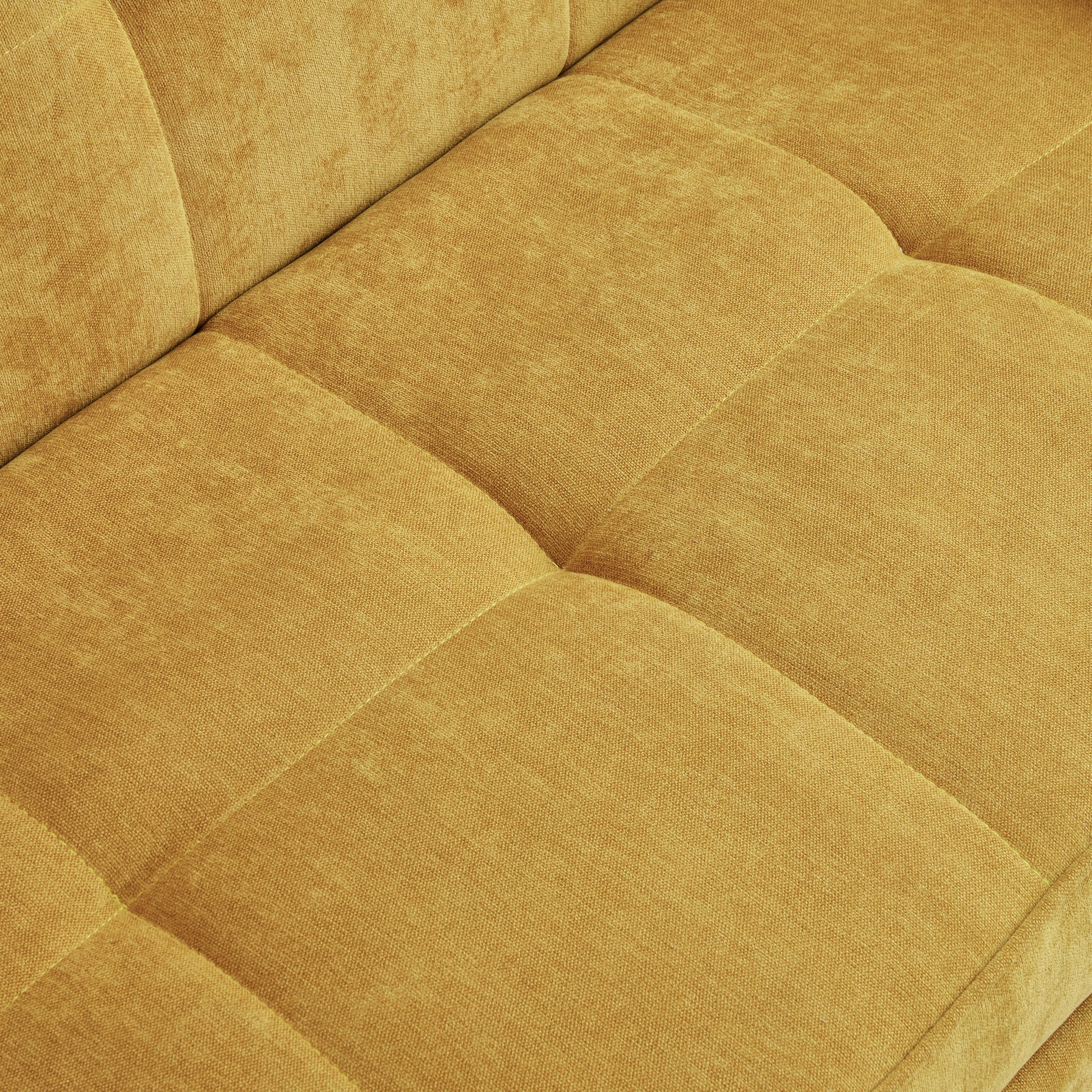 Closeup of textured mustard yellow chenille fabric on a tufted sofa cushion