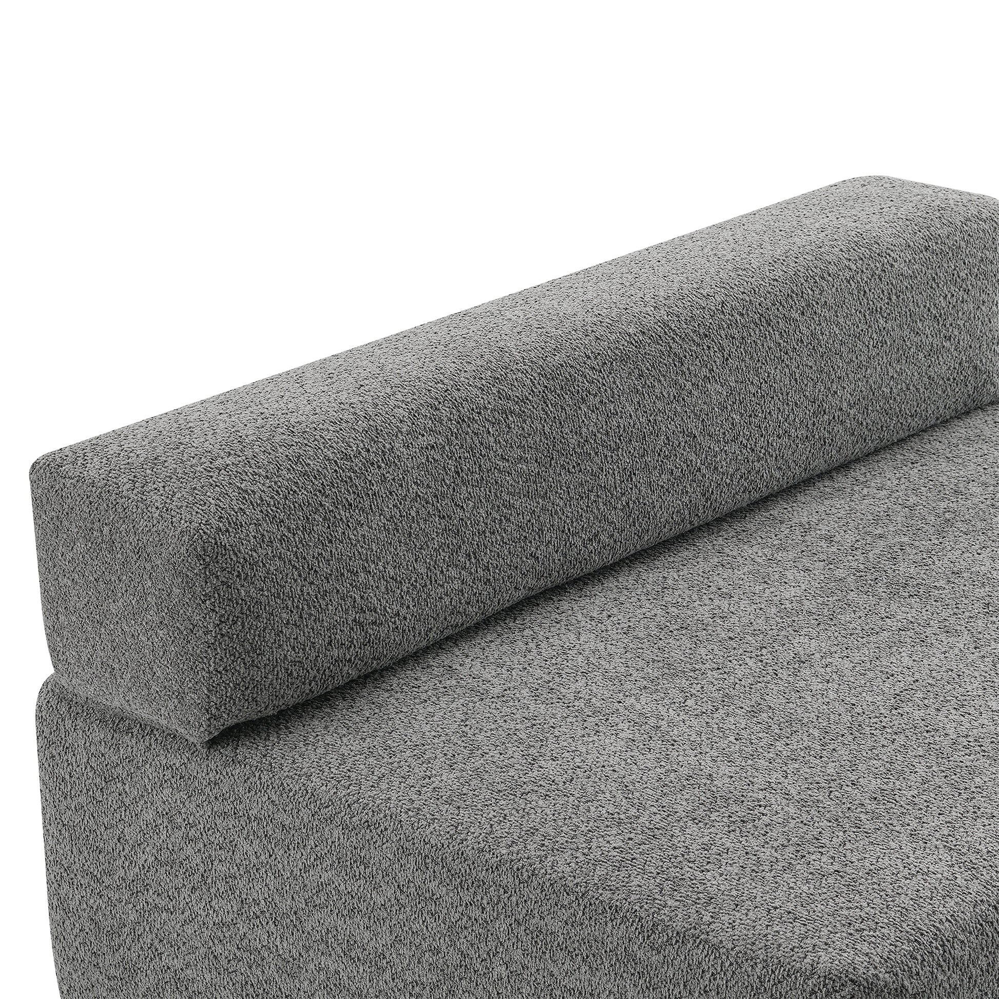 Closeup of a textured grey fabric sofa cushion with a rounded bolster