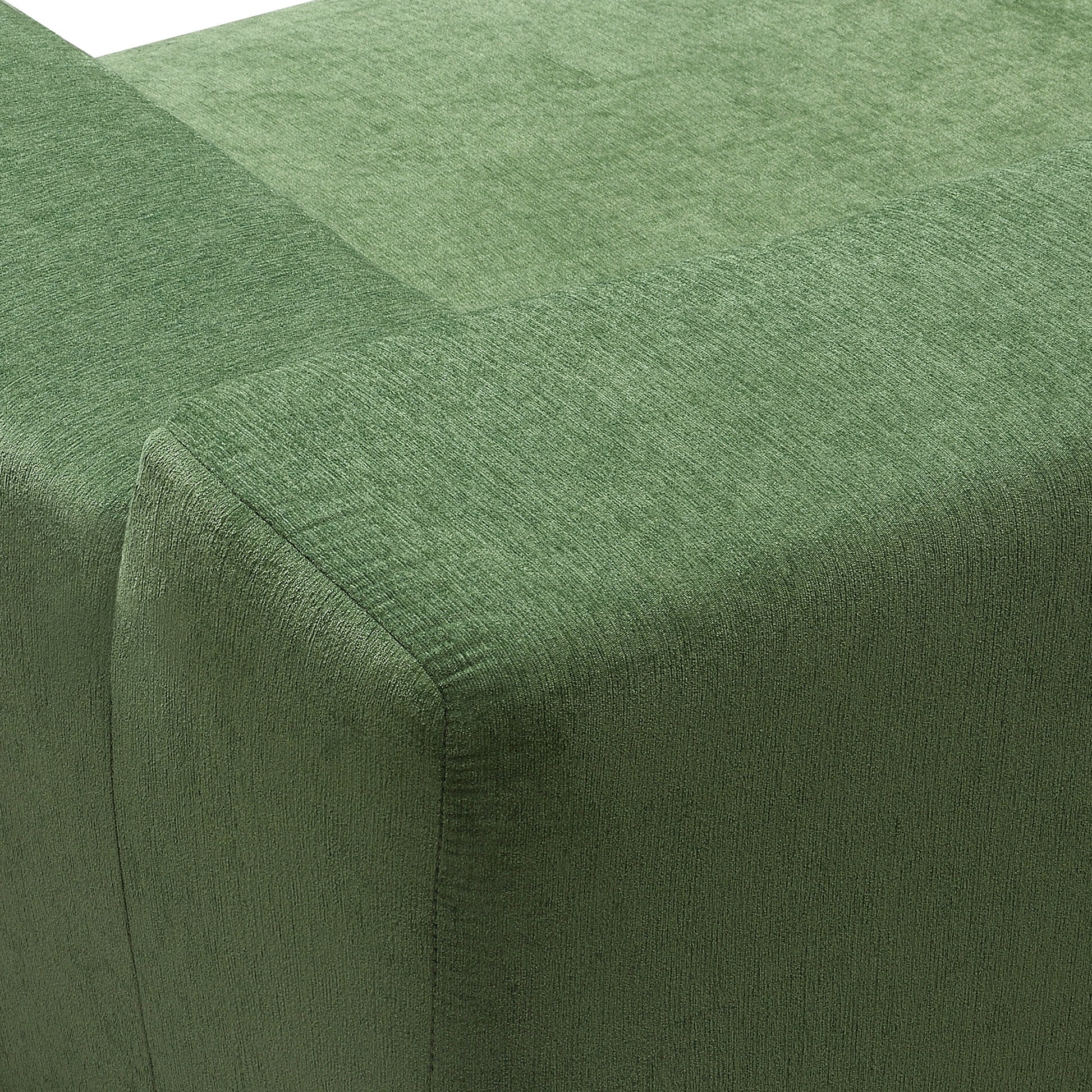 Closeup of a textured green fabric on a sofa armrest showcasing its woven detail