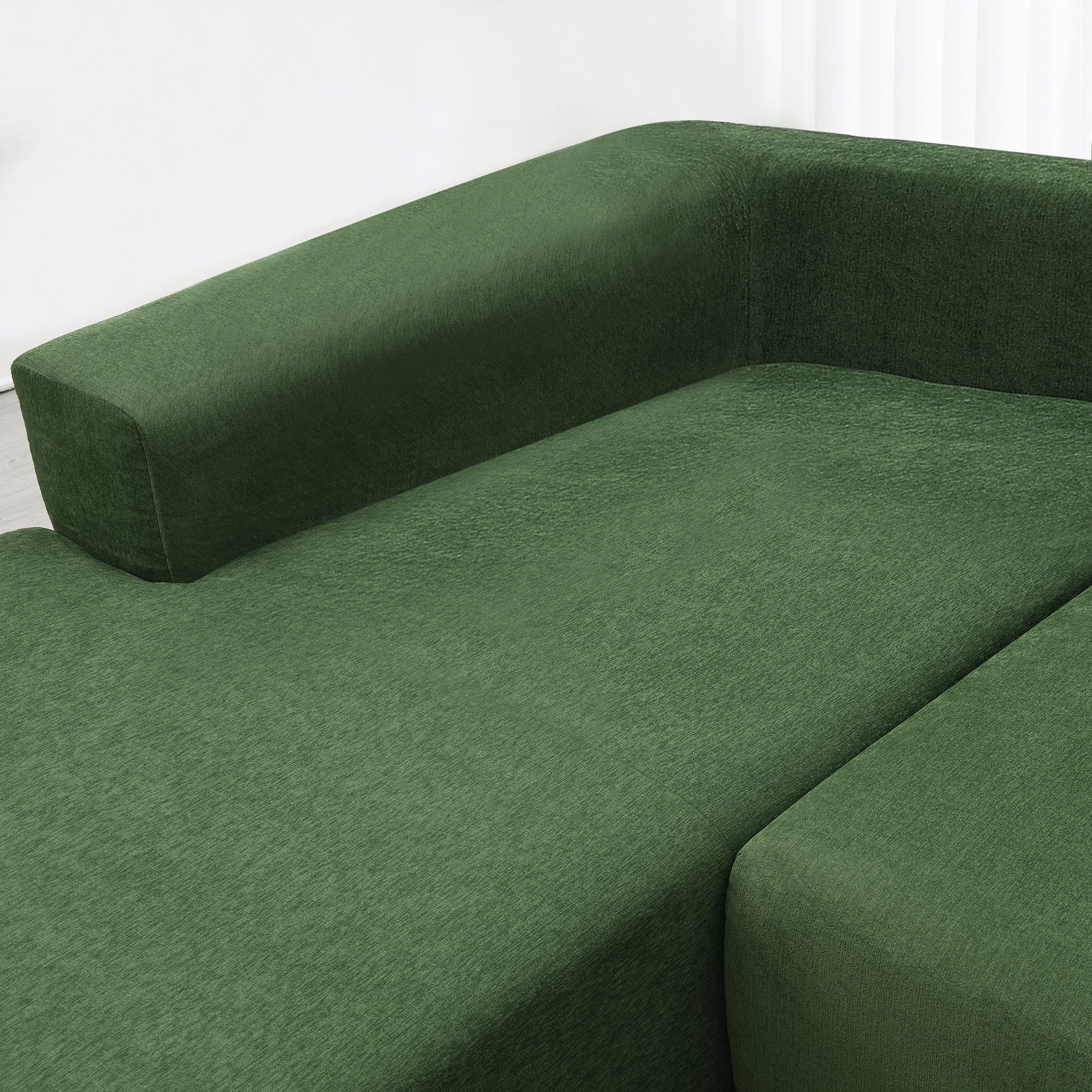 Deep forest green sectional sofa with plush textured fabric upholstery