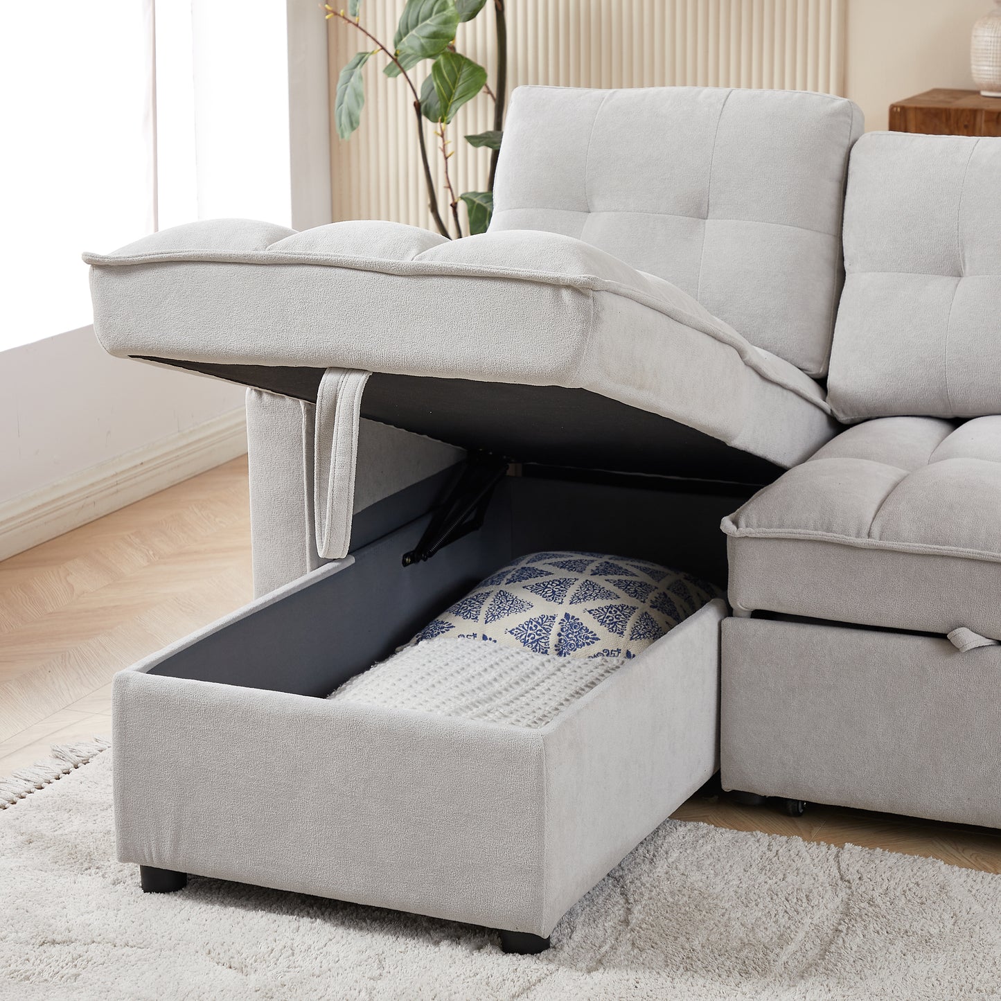 Light grey sectional sofa with open storage compartment revealing a blue patterned cushion