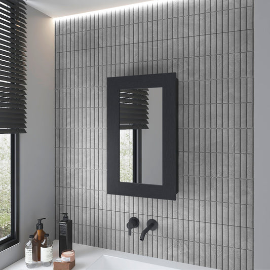 Dark oak framed bathroom mirror reflecting blinds and trees on textured gray tile wall