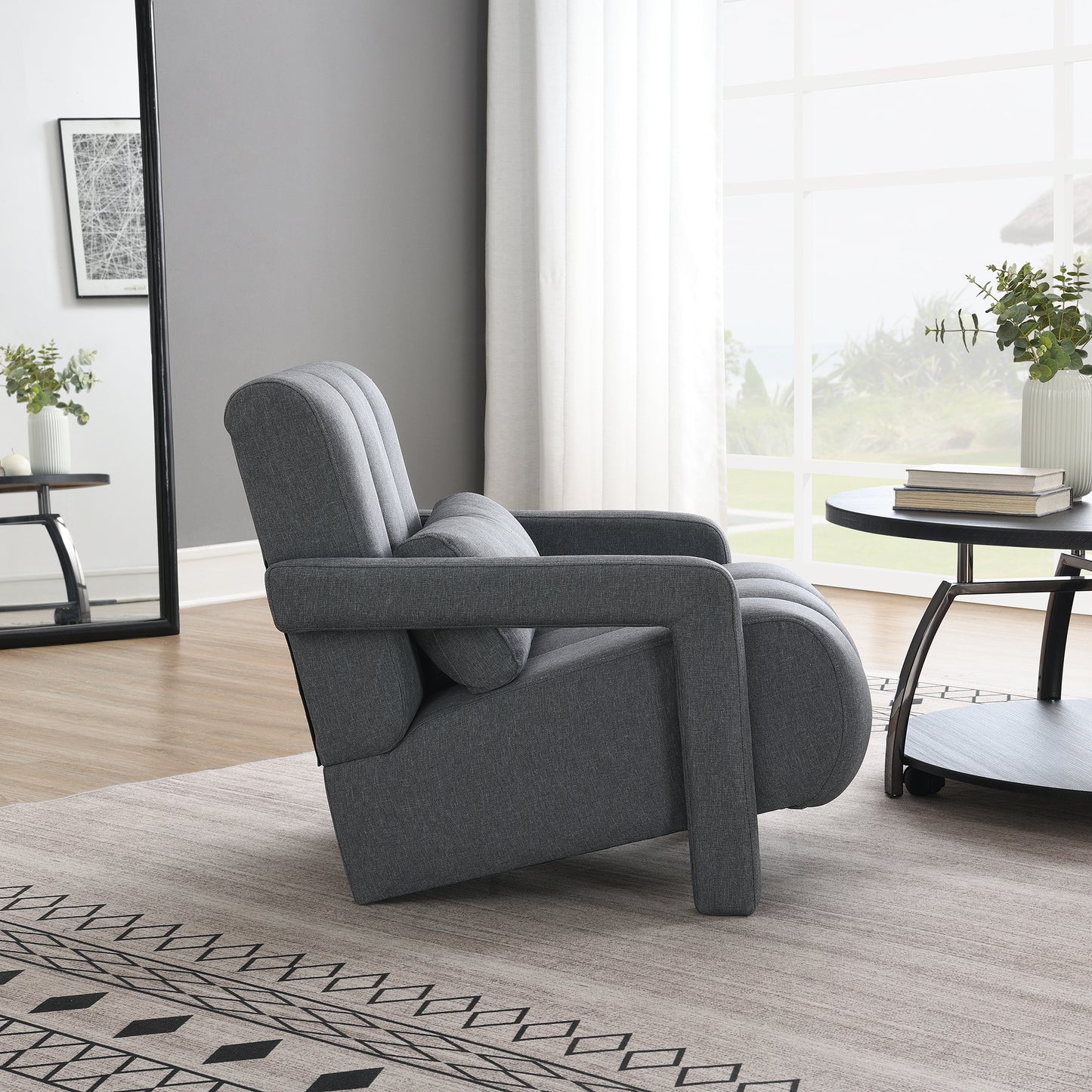 Dark grey upholstered armchair with channel stitching and a lumbar pillow