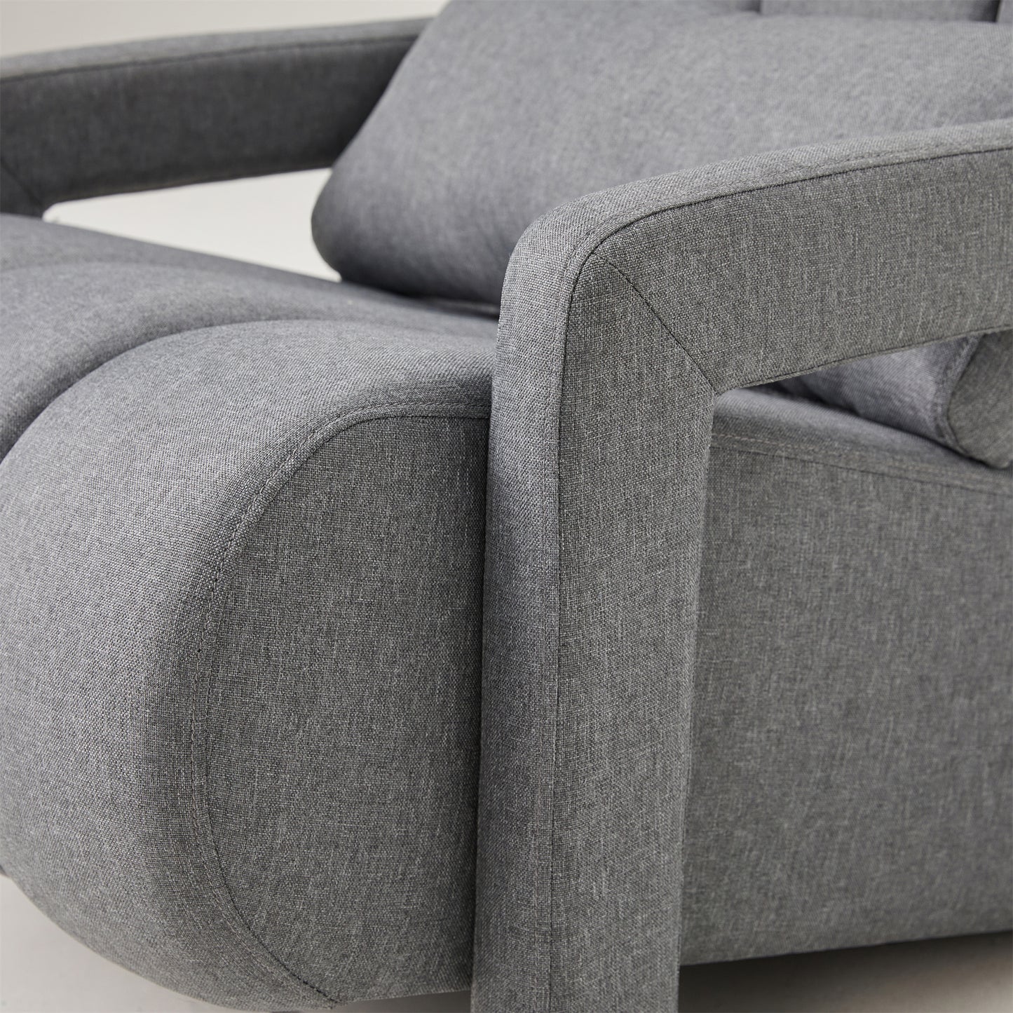 Closeup of a textured gray fabric armchair with curved arms and visible stitching detail