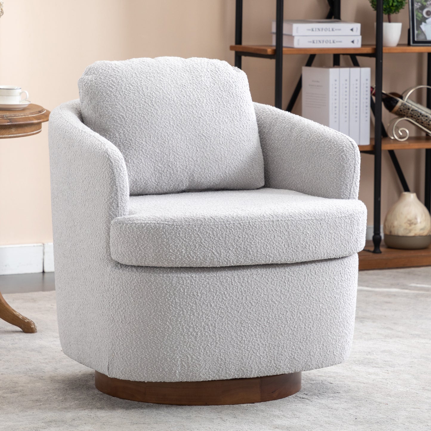 Plush grey boucle accent chair with curved arms and a swivel wooden base