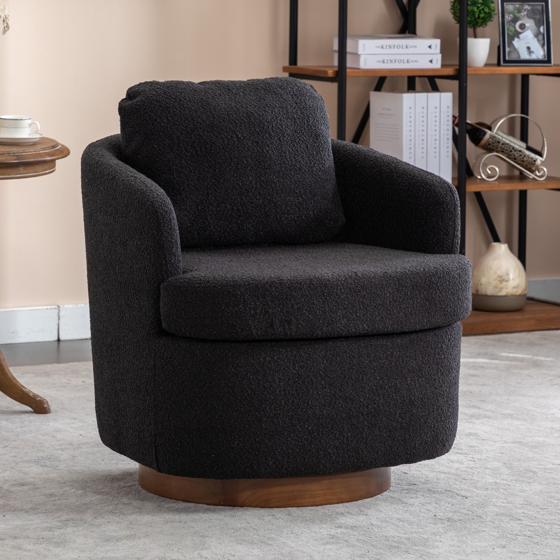 Black boucle swivel chair with plush seat and round wooden base perfect for modern living rooms