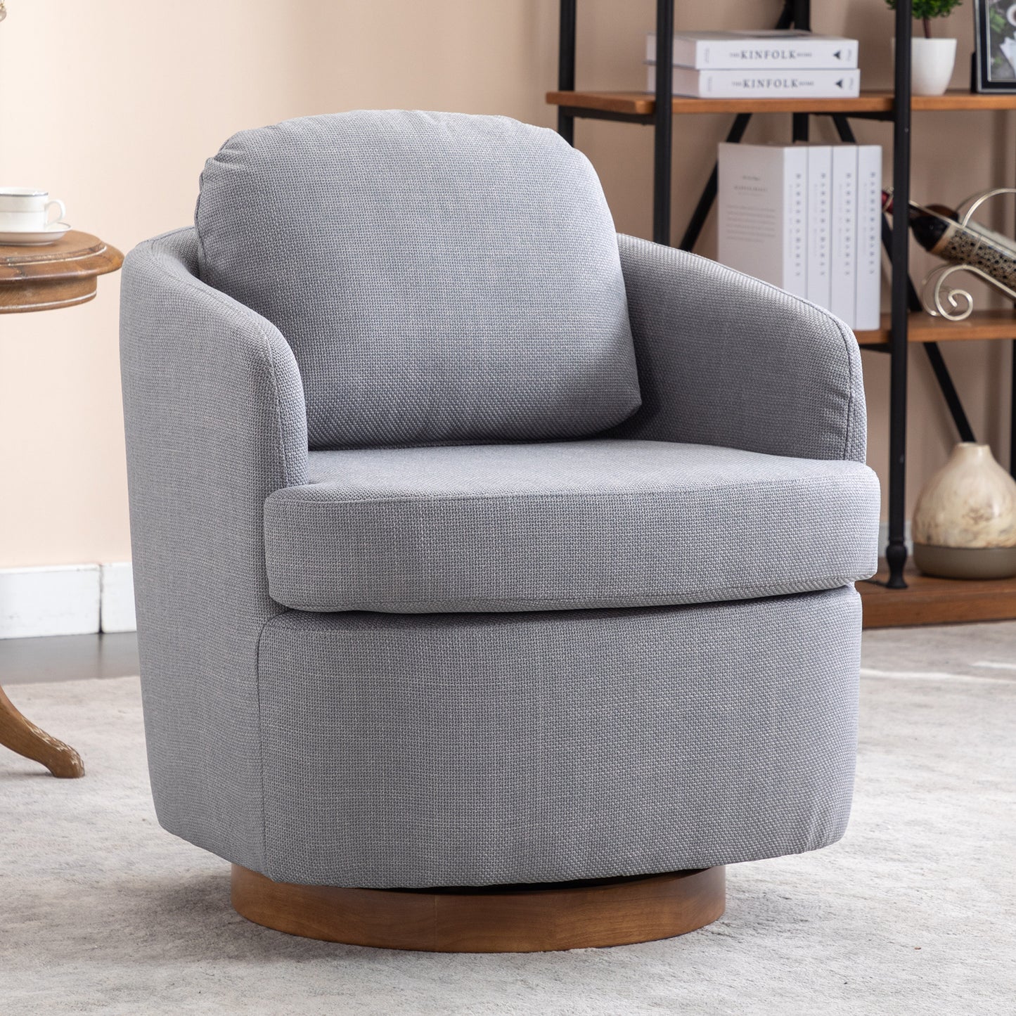 Modern grey fabric swivel chair with a round wooden base