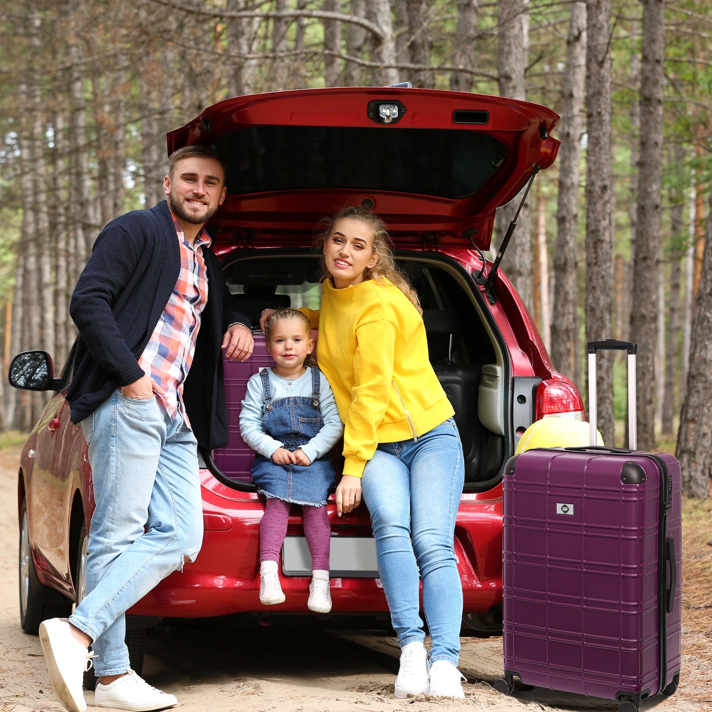 A family with a young girl by a red car with a purple suitcase ready for a road trip