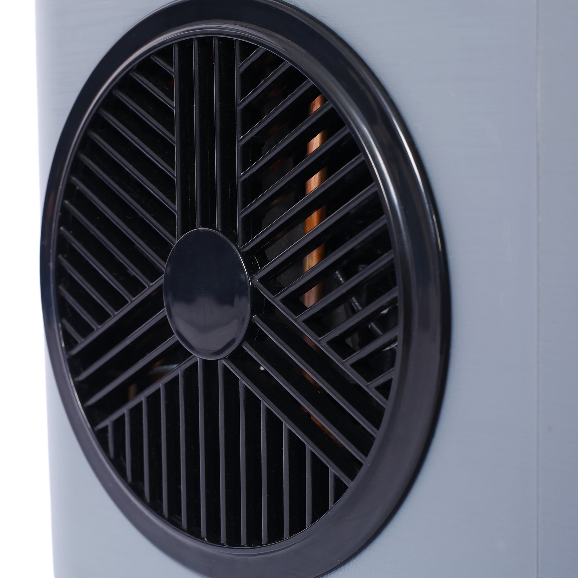 Closeup of black spiral grille on a light gray electric heater