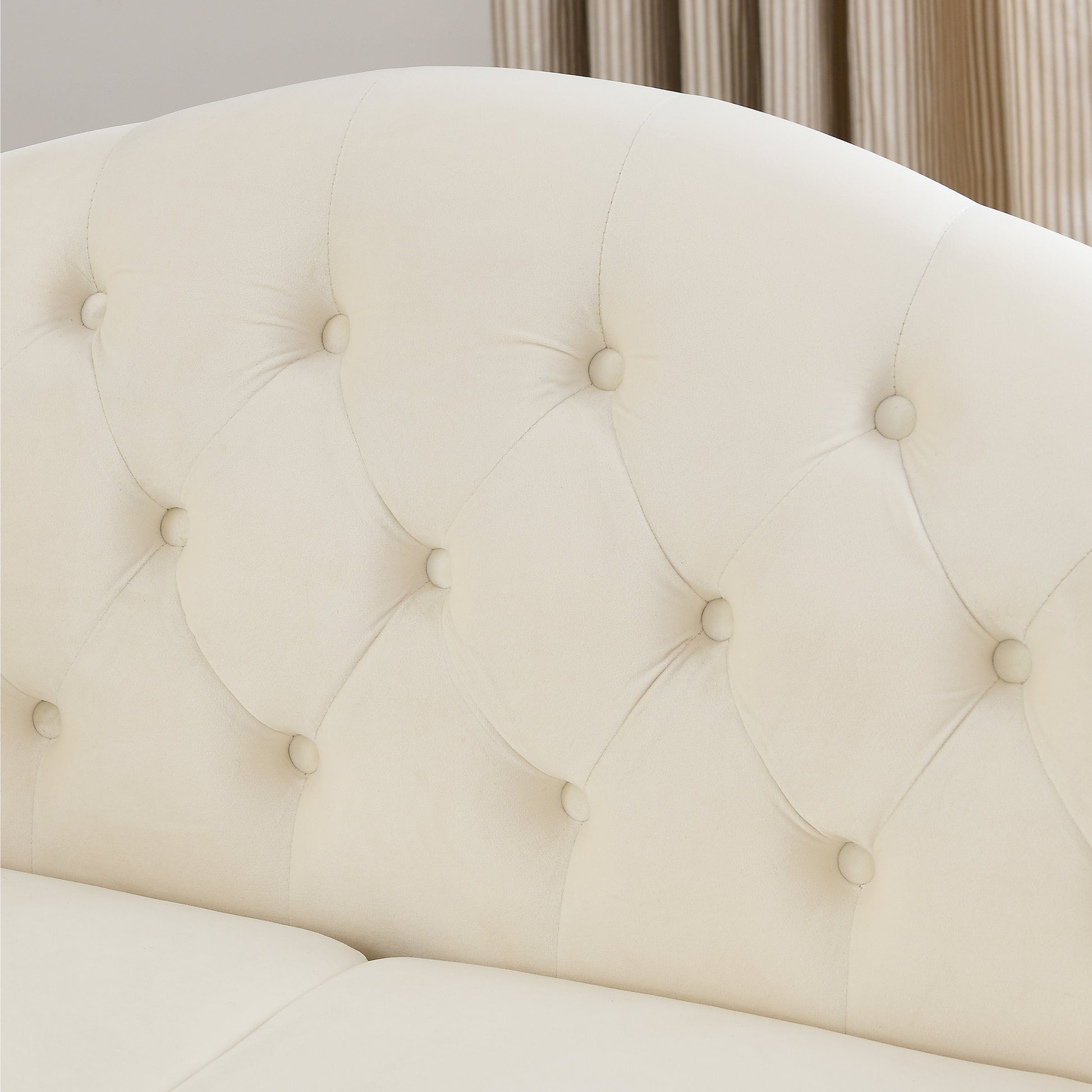 Cream velvet tufted sofa backrest with button accents providing elegant seating