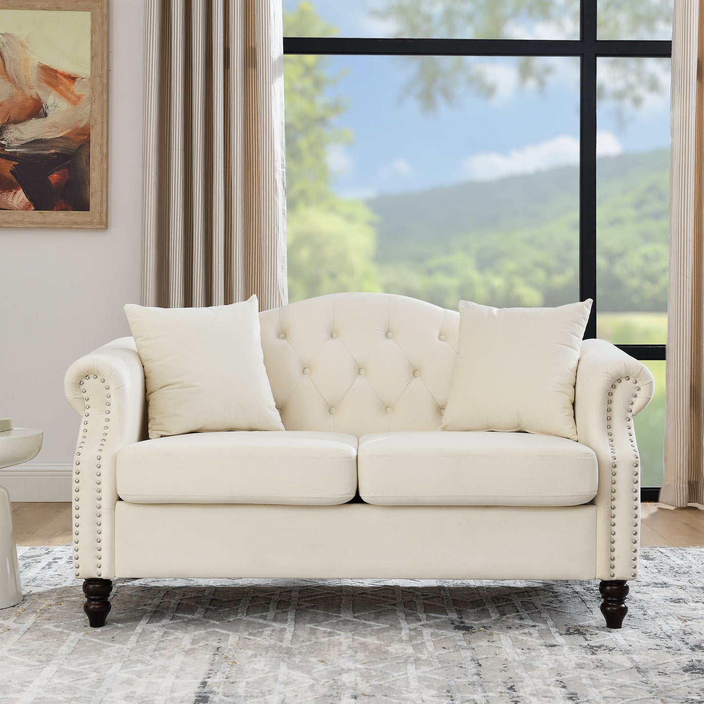 Tufted cream velvet loveseat with nailhead trim and two matching accent pillows