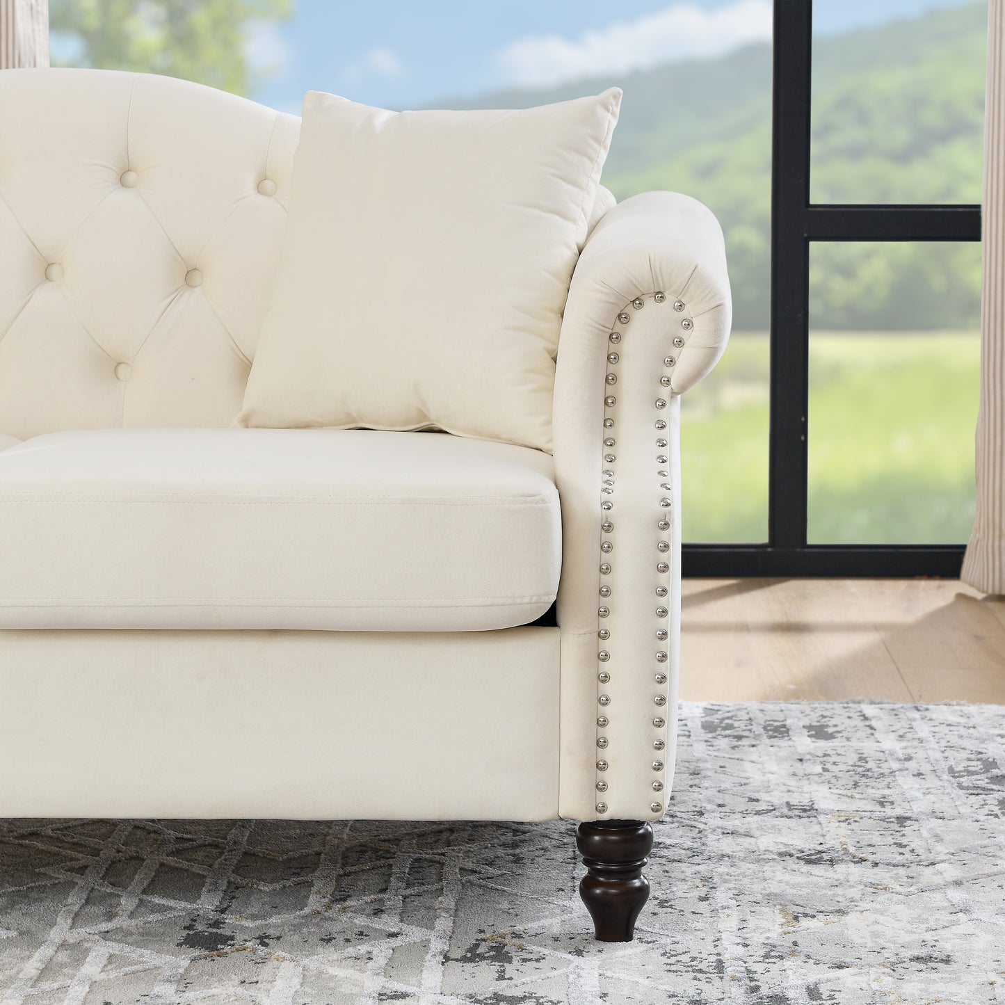 Cream velvet tufted sofa with silver nailhead trim and plush cushion