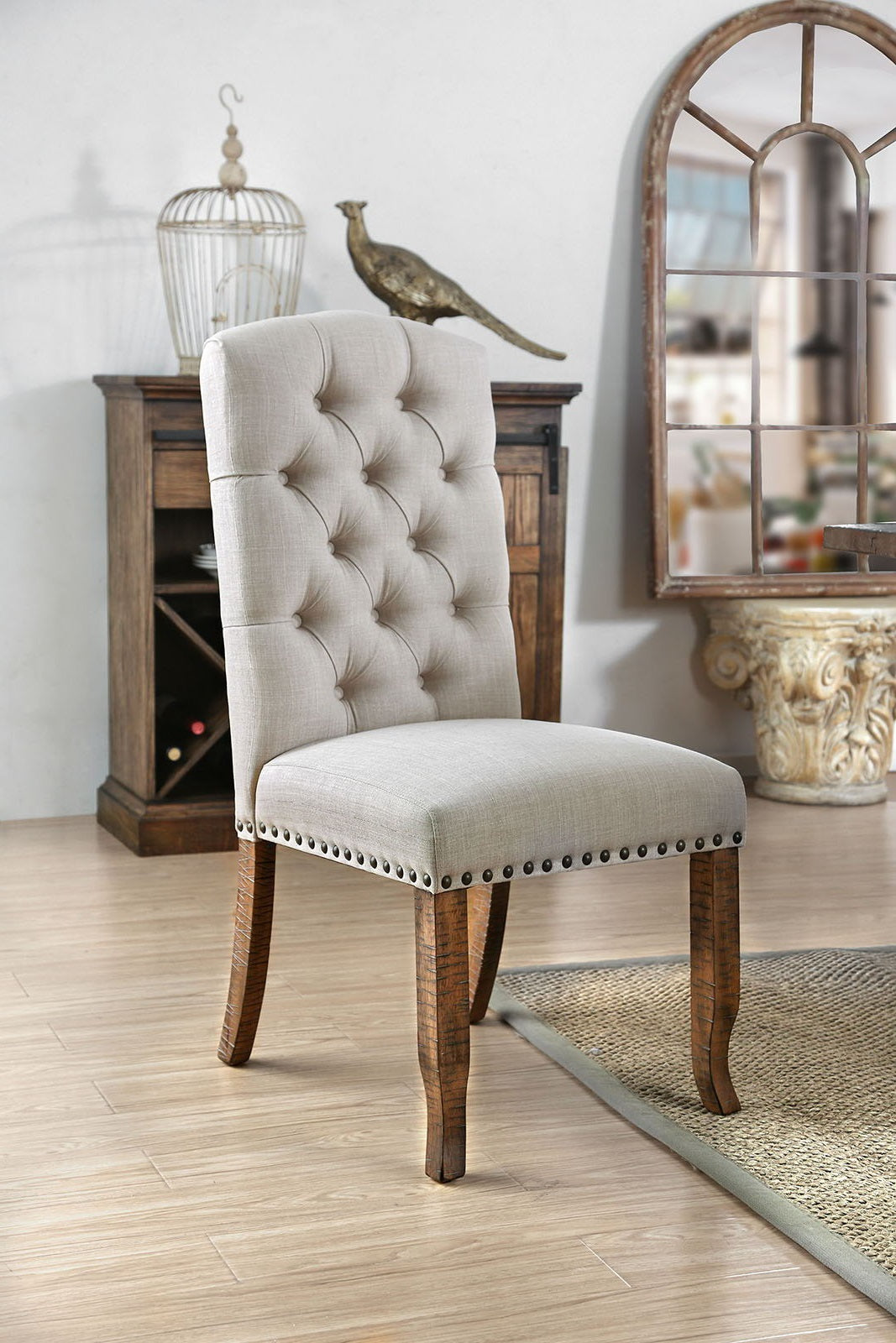 Tufted linen dining chair with nailhead trim and distressed wood legs