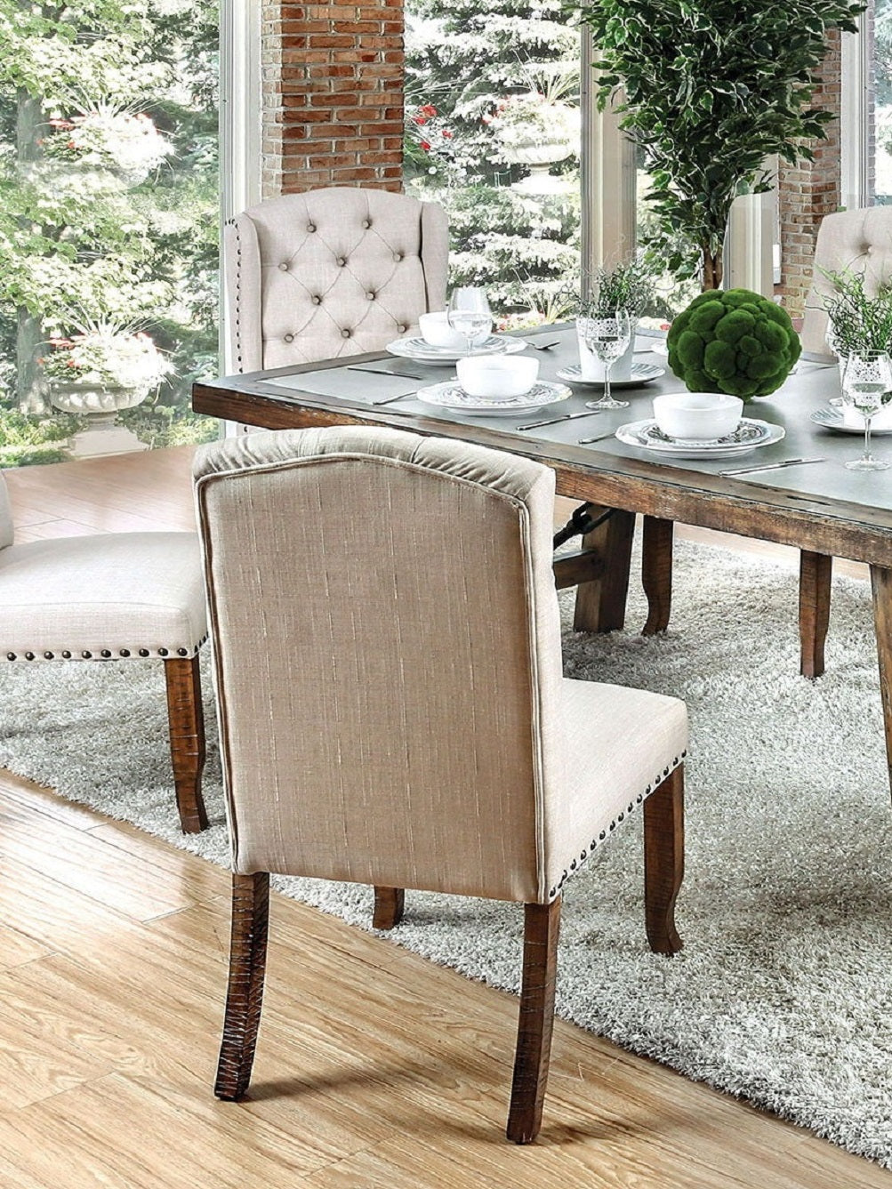 Tufted beige linen dining chair with nailhead trim and dark wood legs