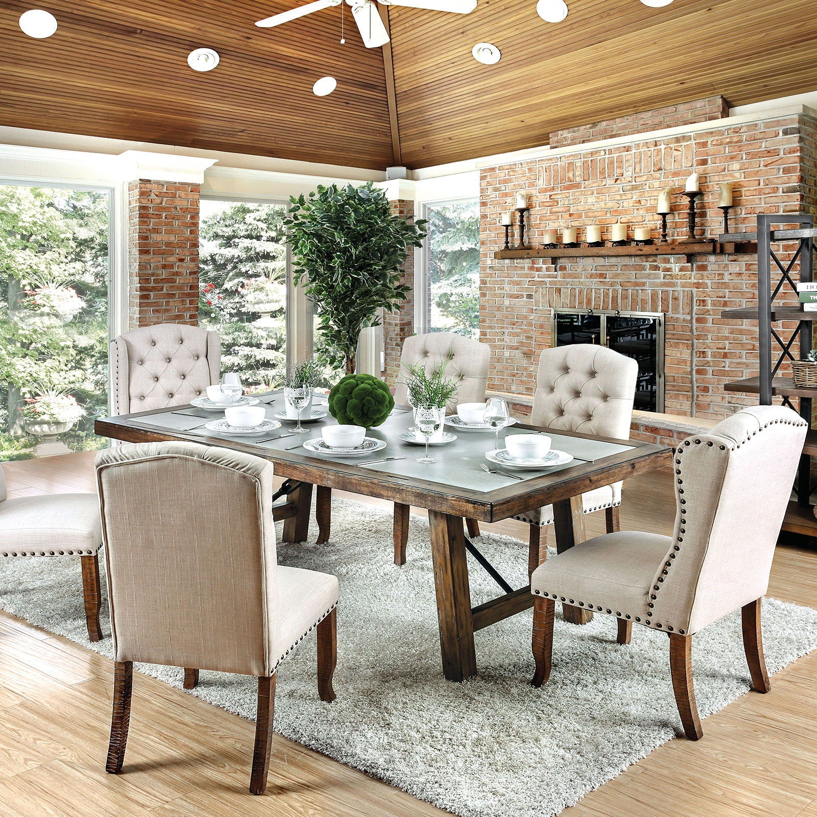 Tufted linen dining chairs with nailhead trim surrounding a rustic wood table