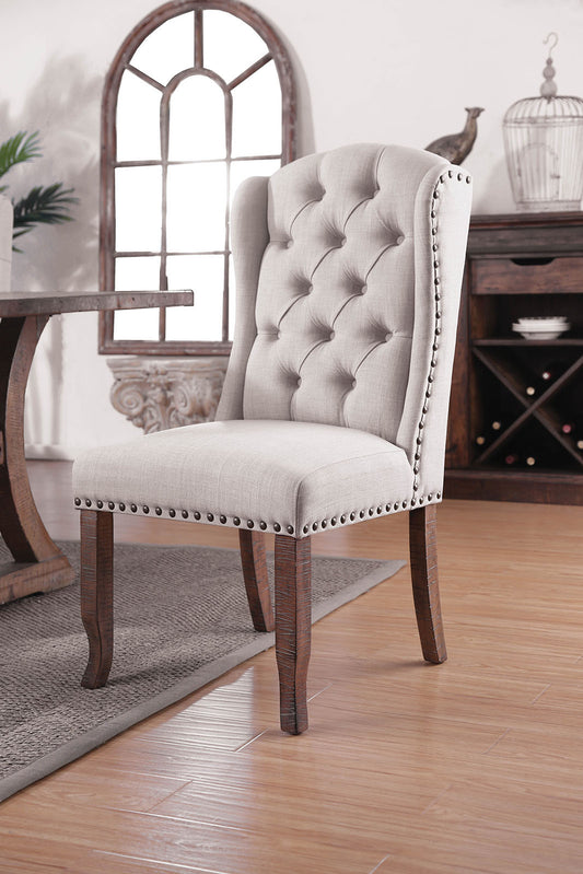 Tufted wingback dining chair in light gray linen with nailhead trim and dark wood legs