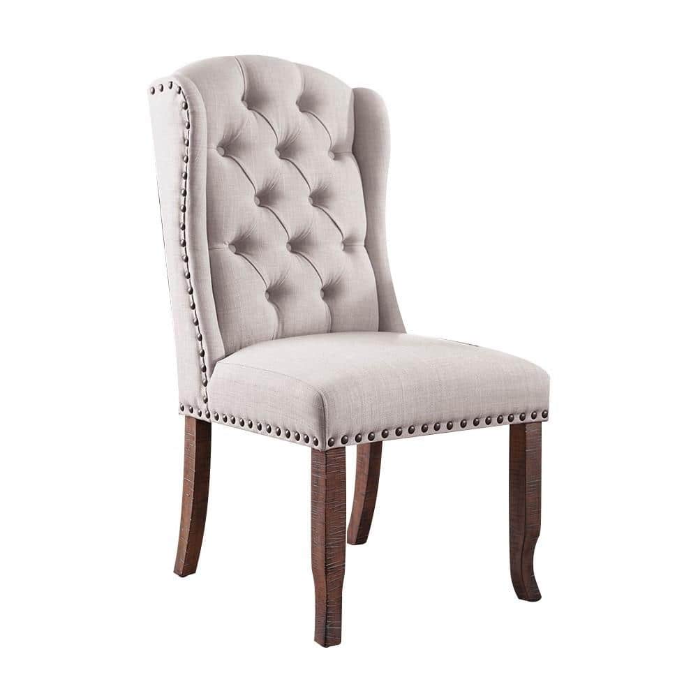 Tufted beige linen dining chair with nailhead trim and dark wood legs