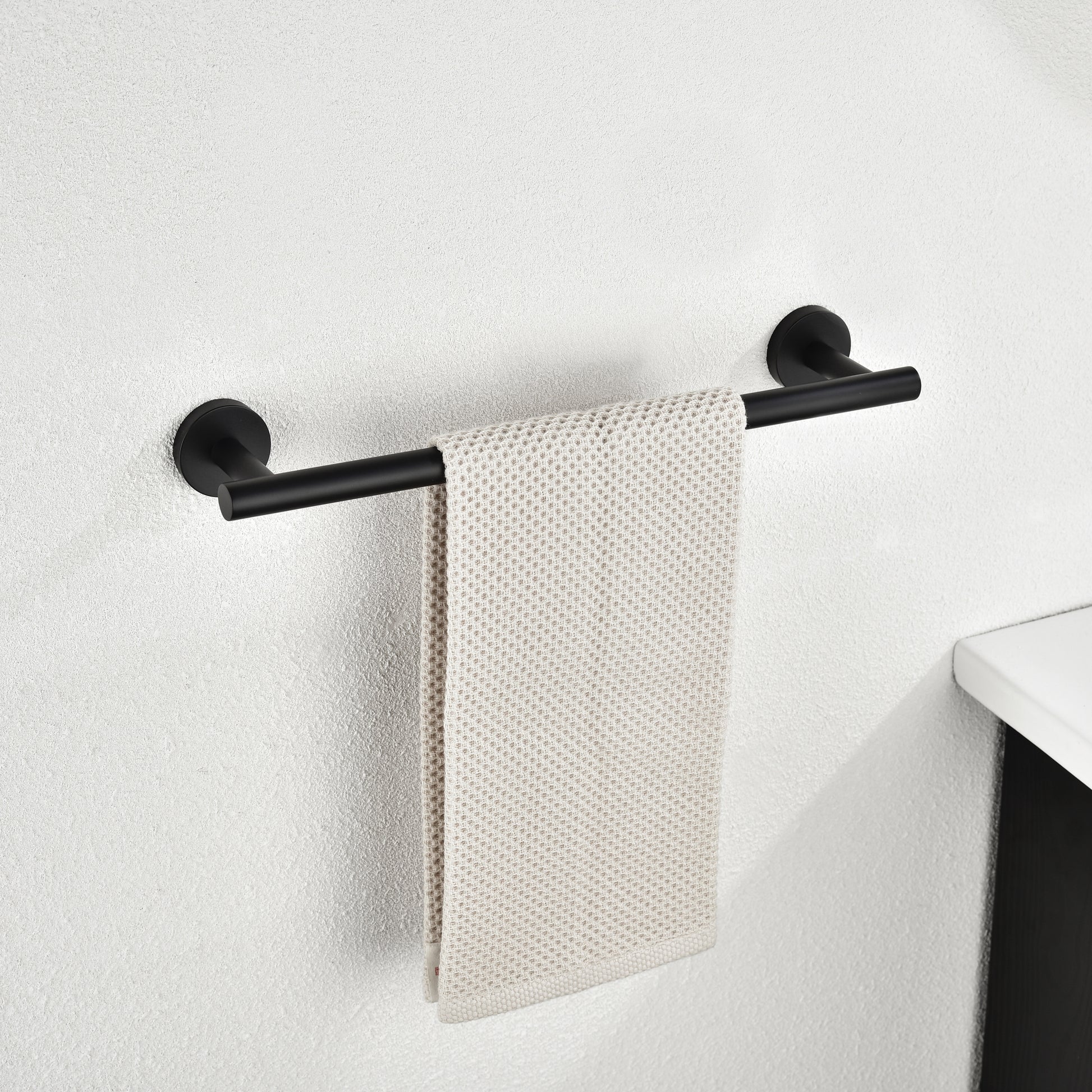 Black modern wallmounted towel bar with a single beige waffleweave towel