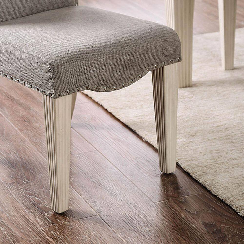 Grey upholstered dining chair with silver nailhead trim and fluted legs