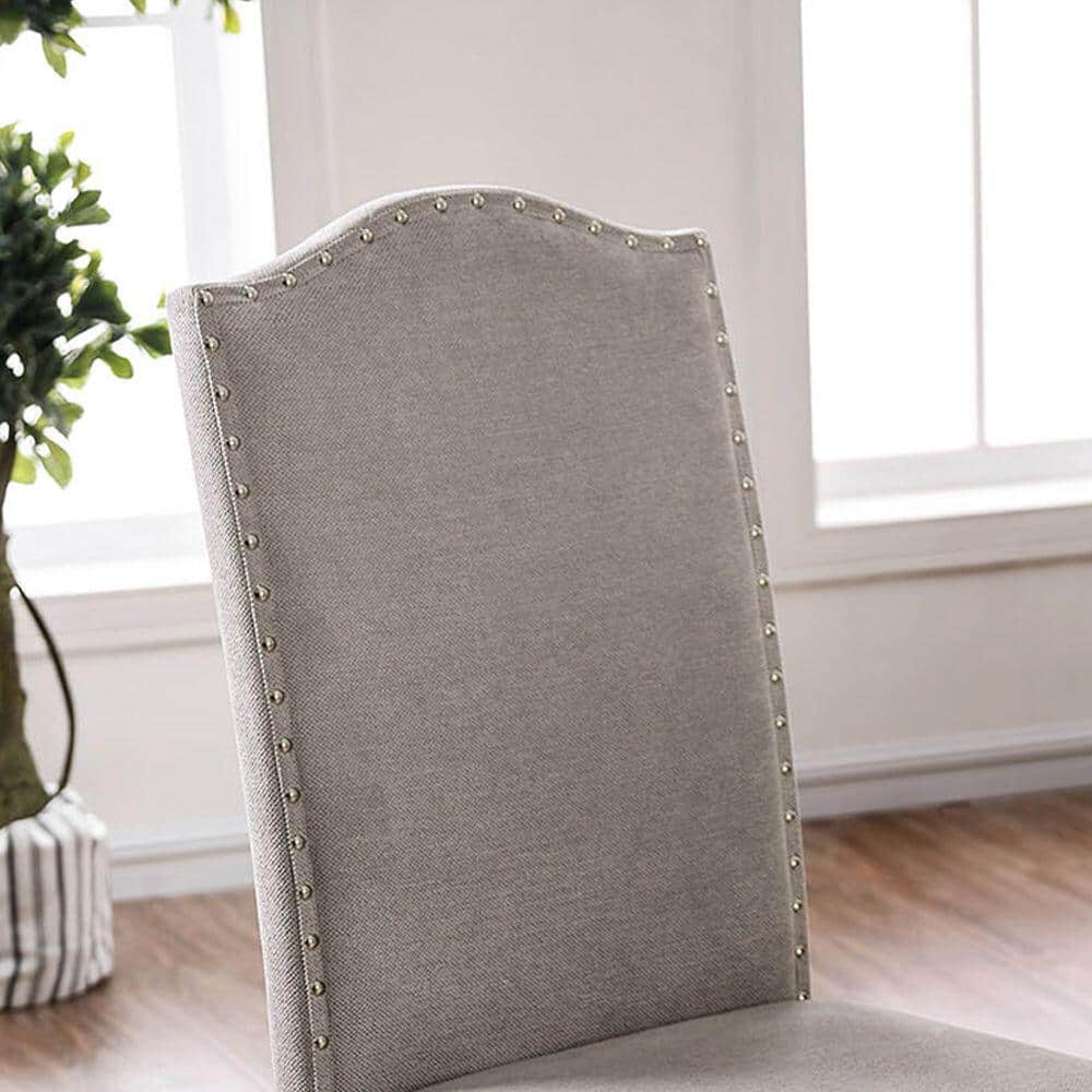 Upholstered dining chair in light grey linen with decorative nailhead trim
