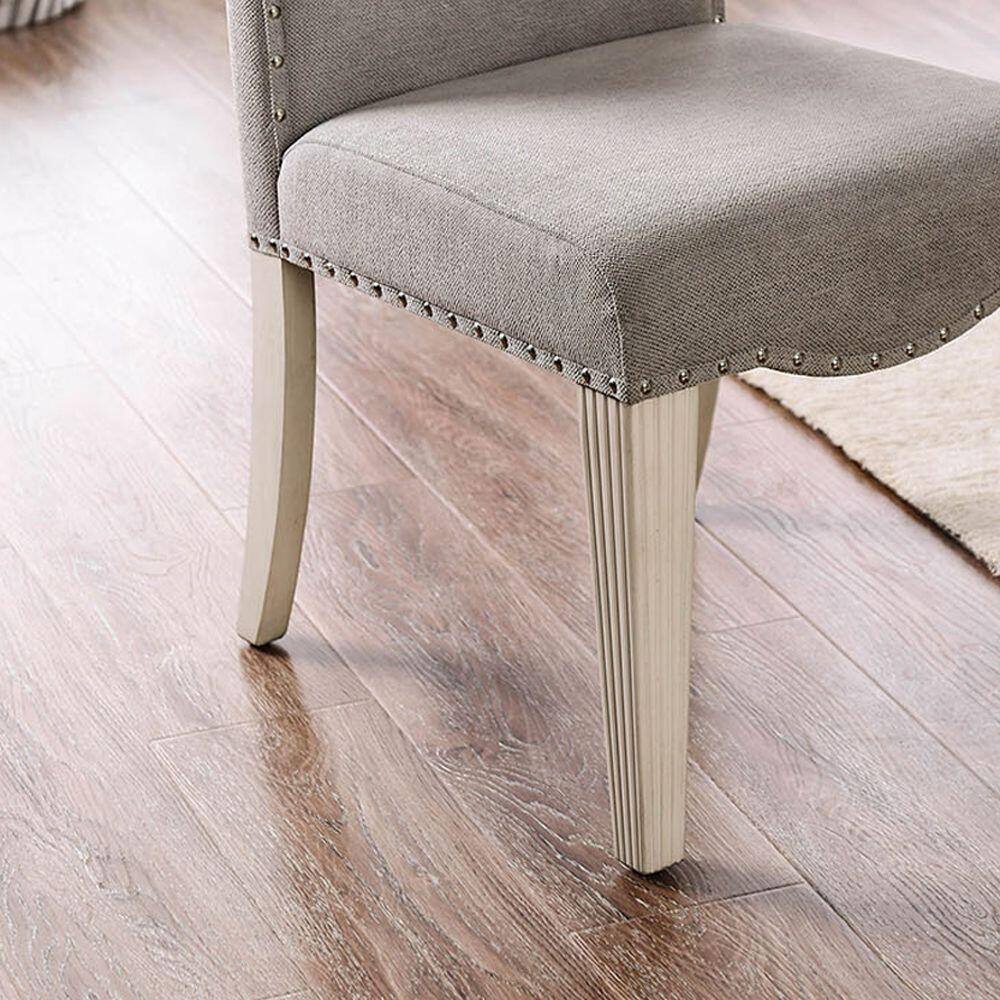 Upholstered dining chair with nailhead trim and carved wood legs