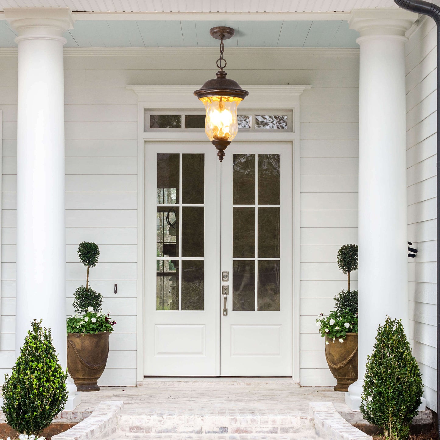 White double doors with glass panes and decorative urns flanking the entrance