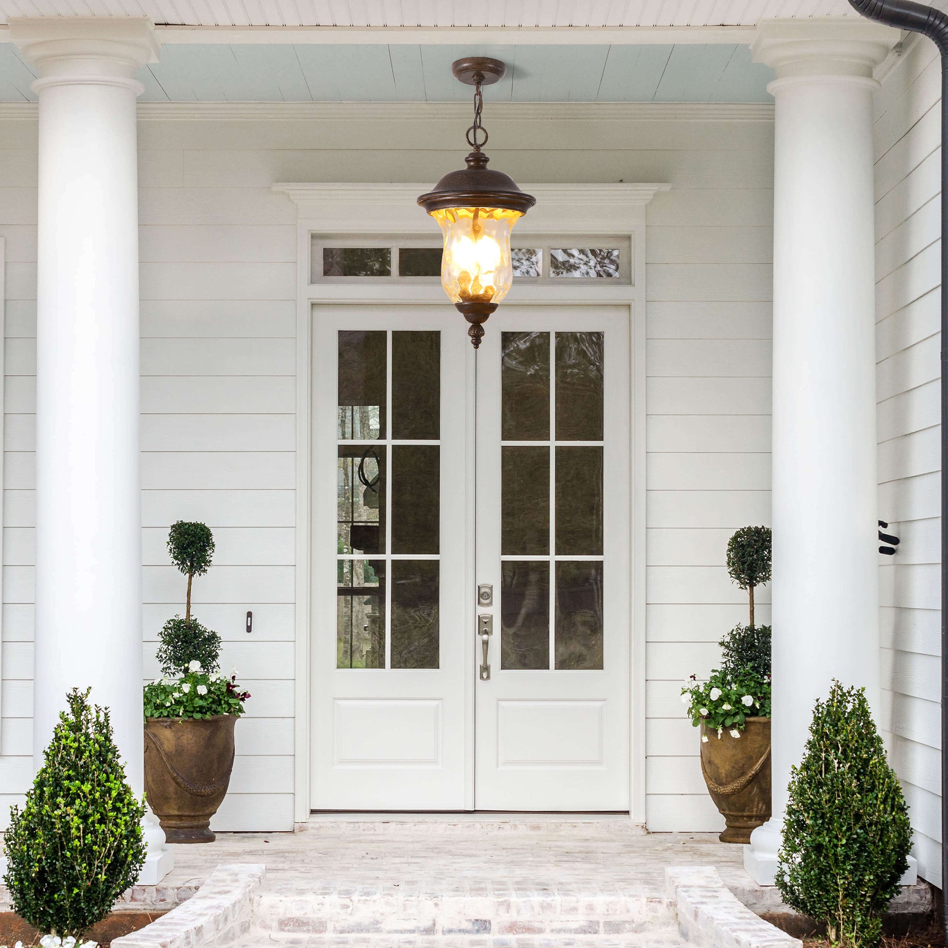 White double doors with glass panes and decorative urns flanking the entrance