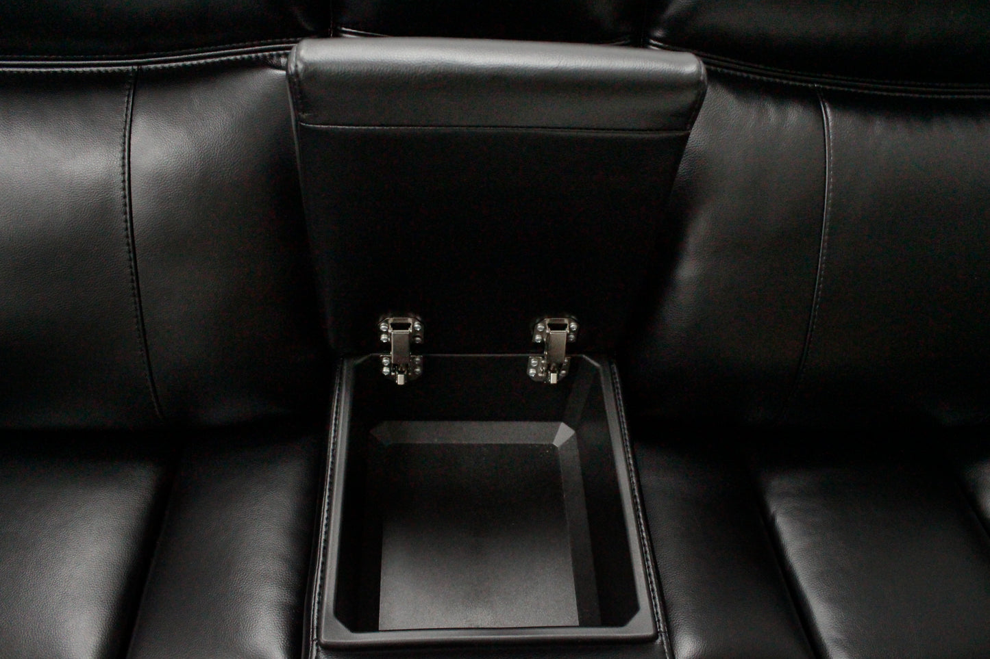 Black leather reclining chair with builtin storage compartment and chrome hinges