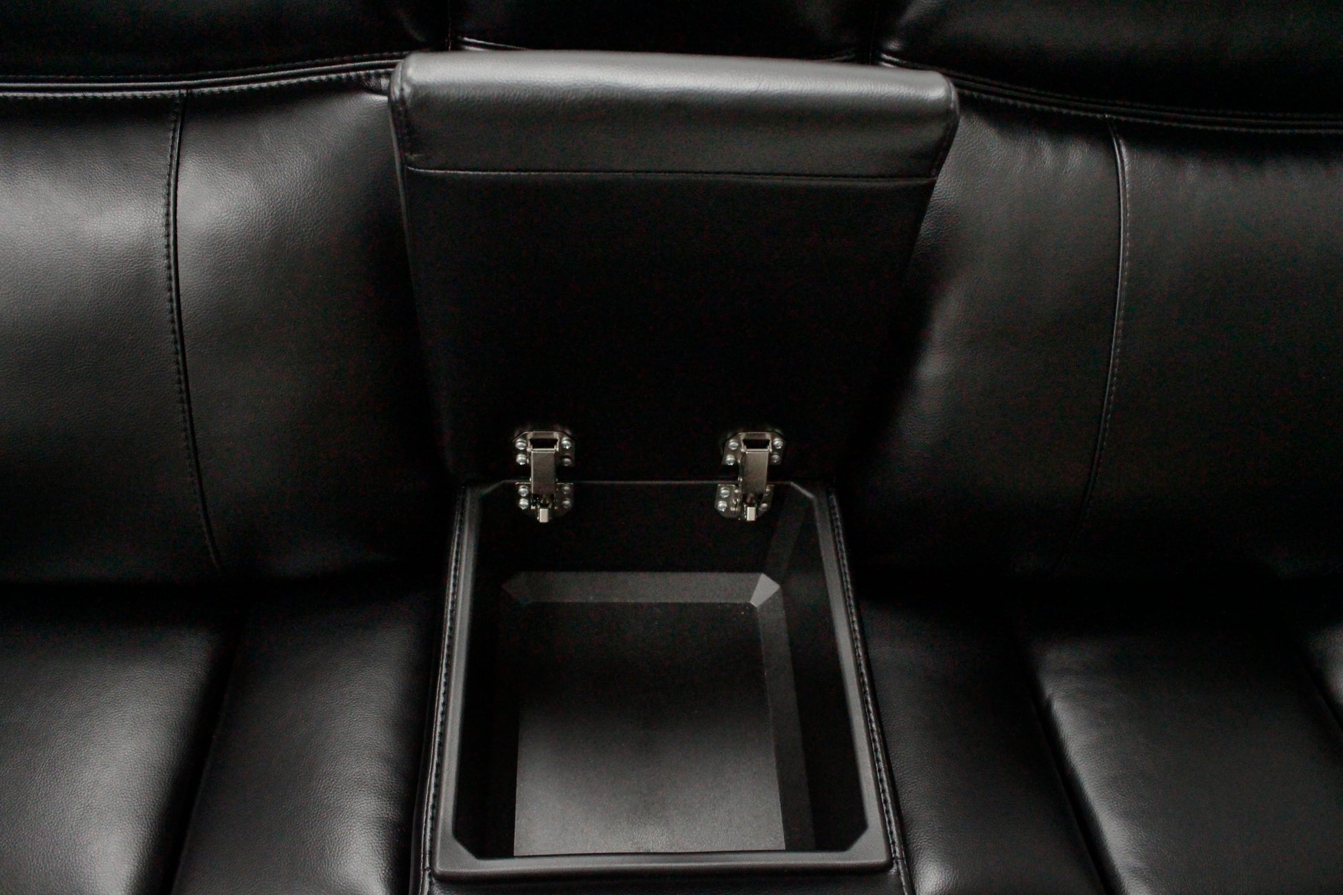 Black leather reclining chair with builtin storage compartment and chrome hinges