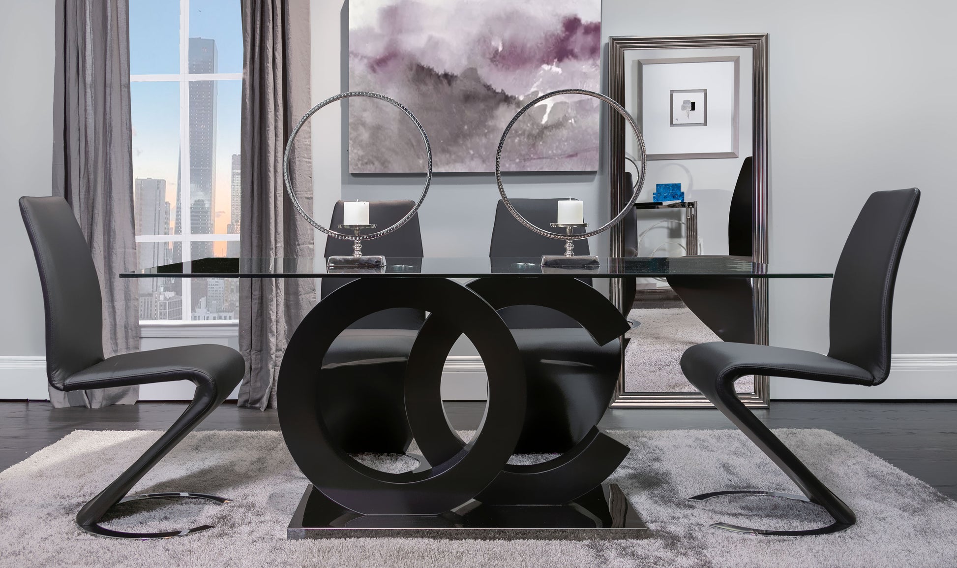Modern dining table with glass top and black sculptural base paired with four sleek black chairs