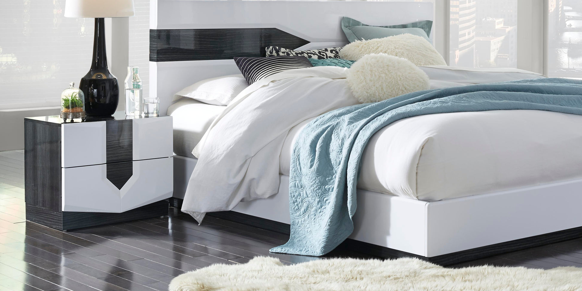 Modern white bed frame with dark wood accents and plush bedding