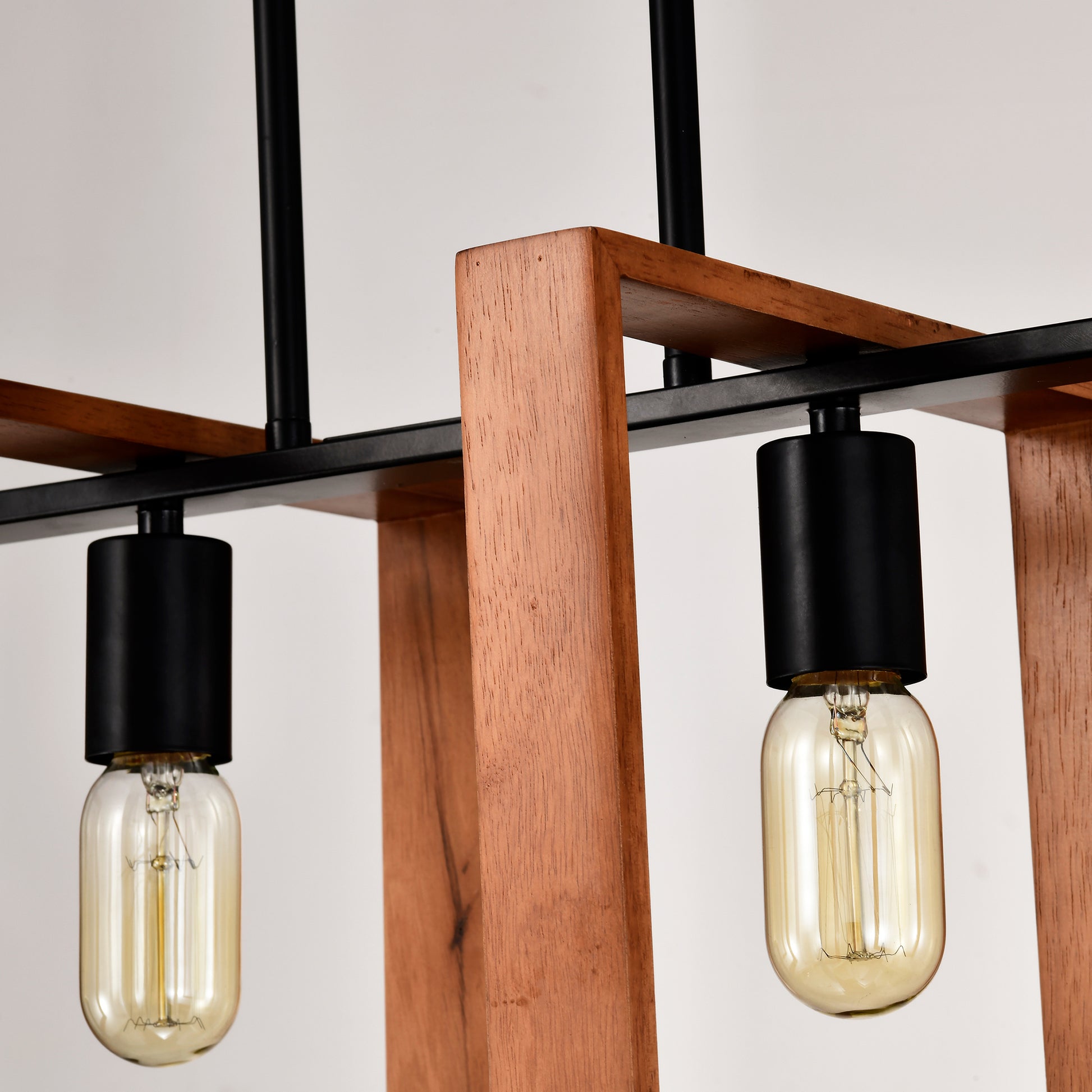 Modern industrial pendant light with wooden frame and black accents featuring Edison bulbs