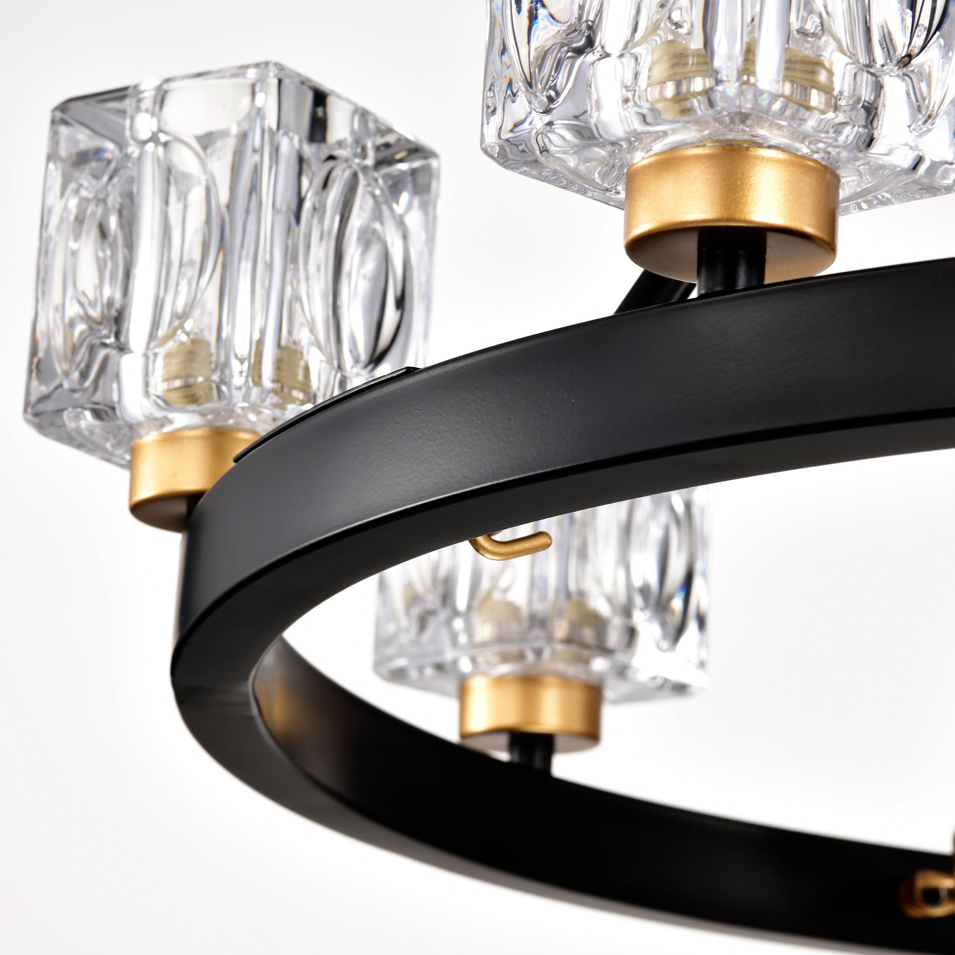 Close up of black metal chandelier with gold accents and clear crystal shades