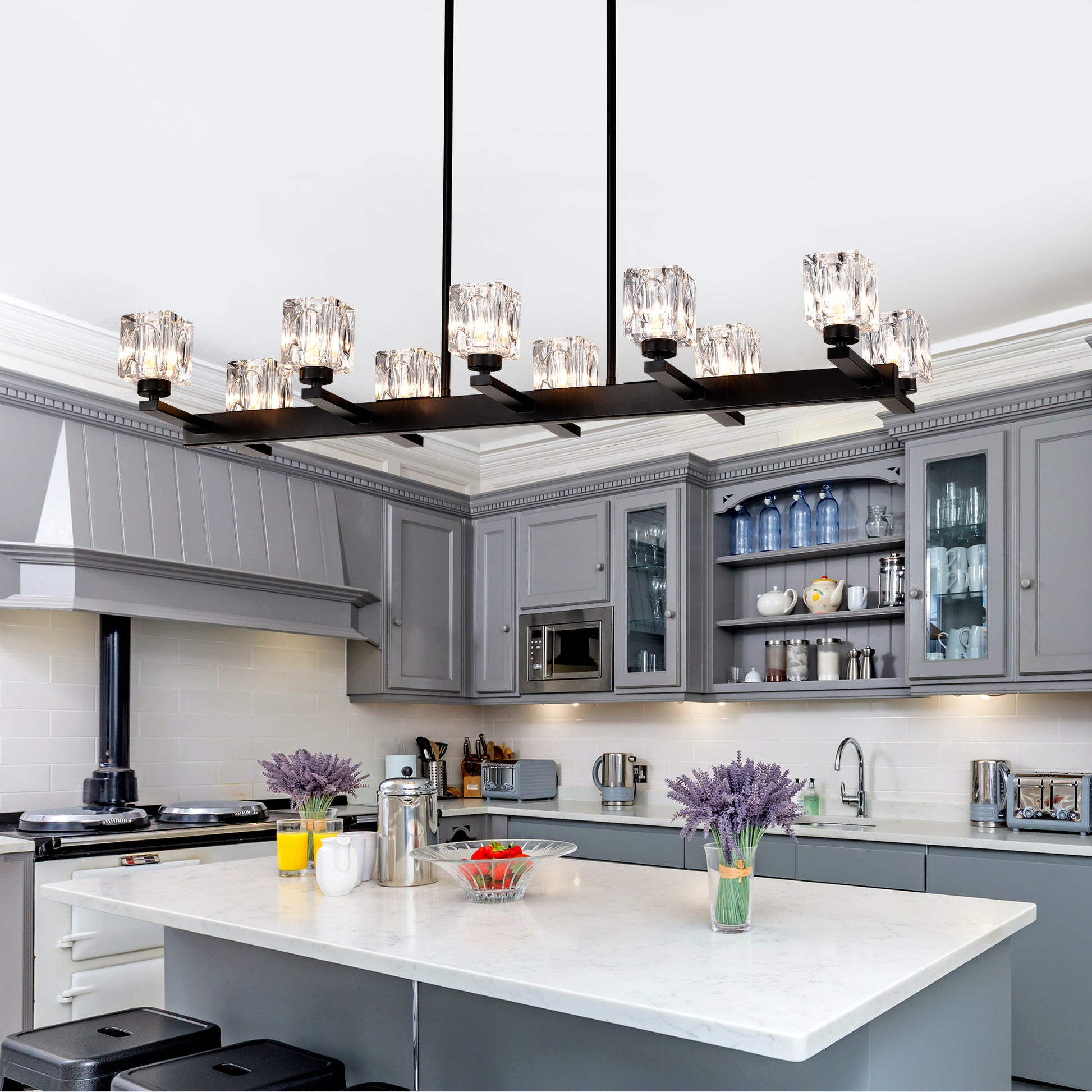 Modern black linear chandelier with crystal cube shades illuminating a grey kitchen island