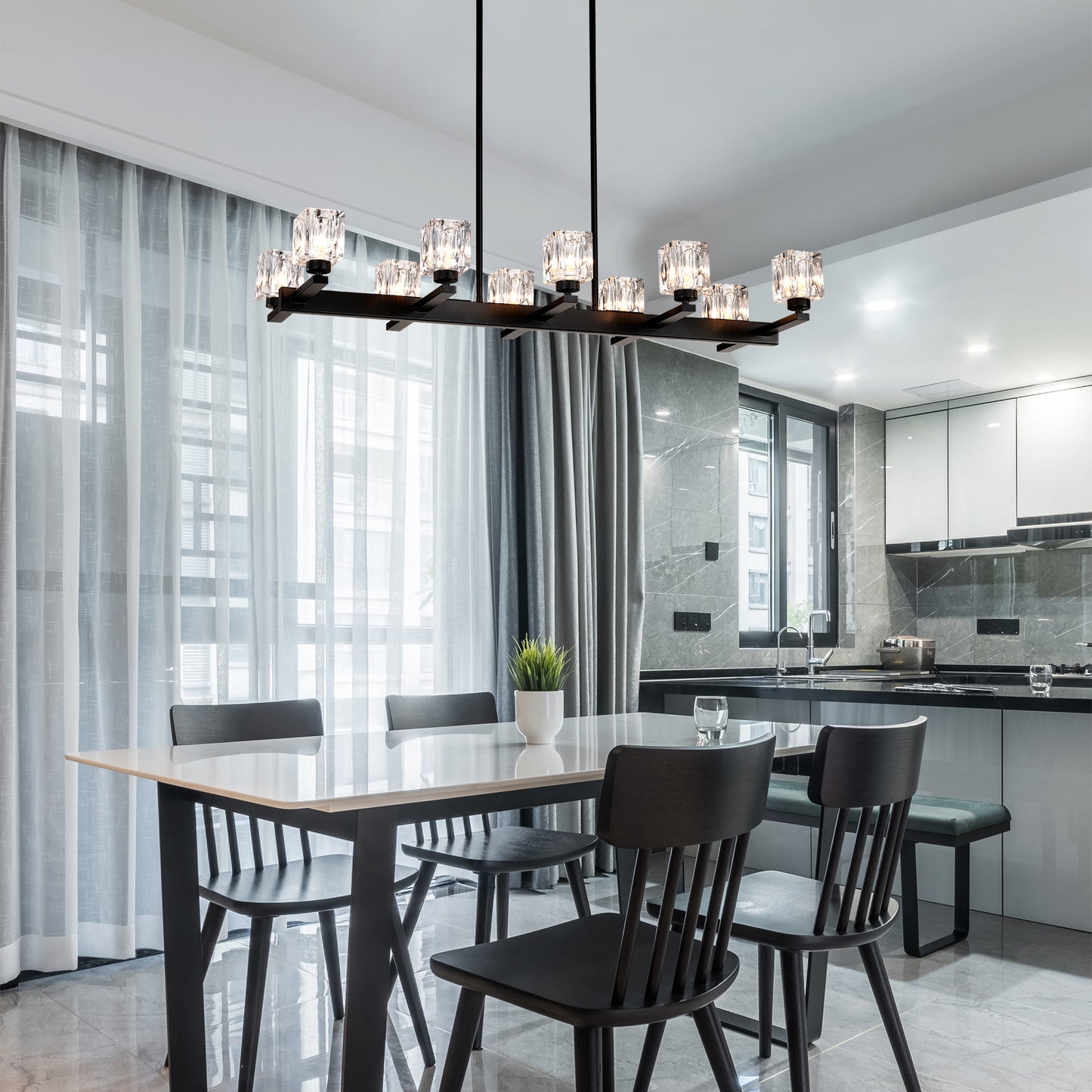 Modern black chandelier with crystal accents illuminating a dining area