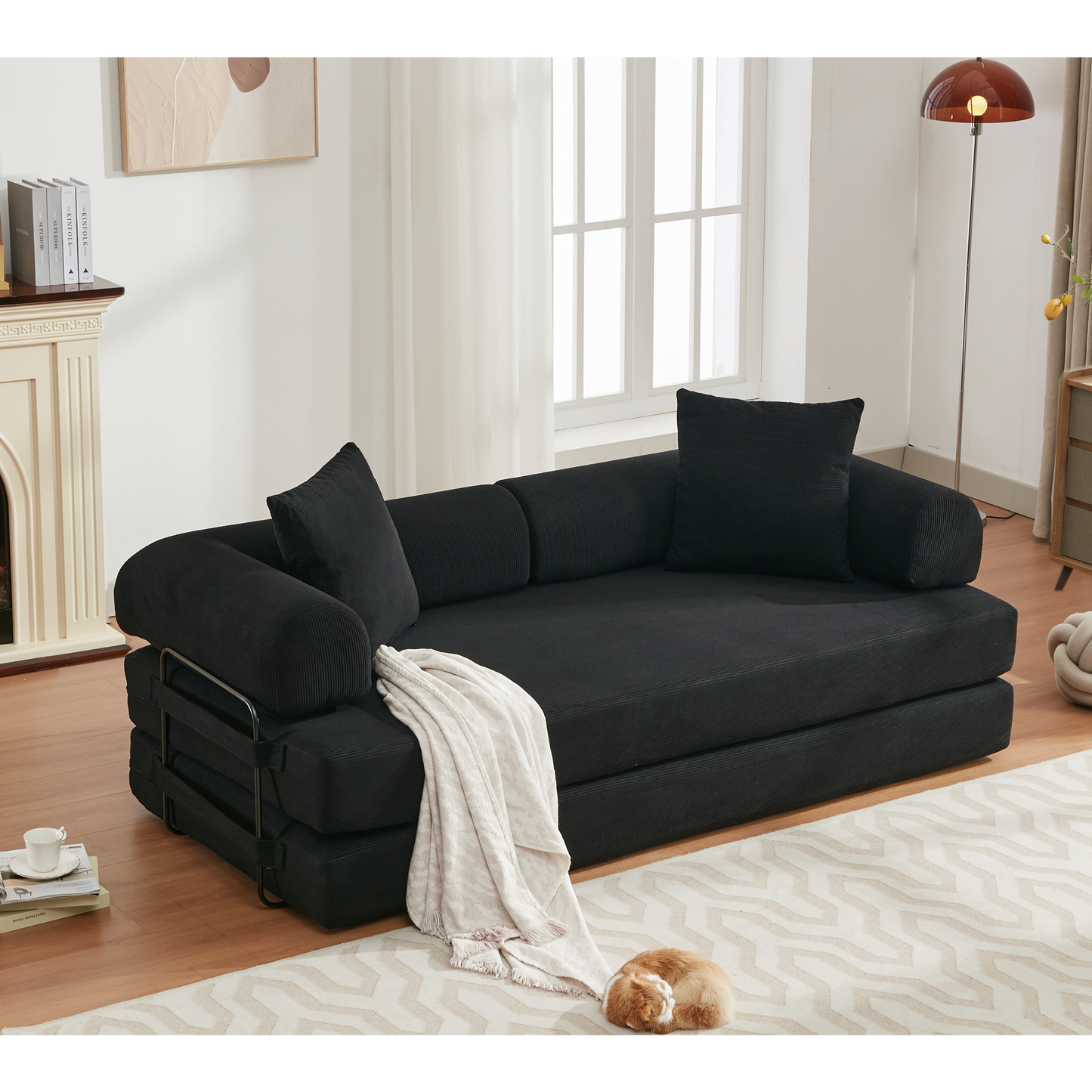 Black corduroy sofa bed with metal frame and throw blanket